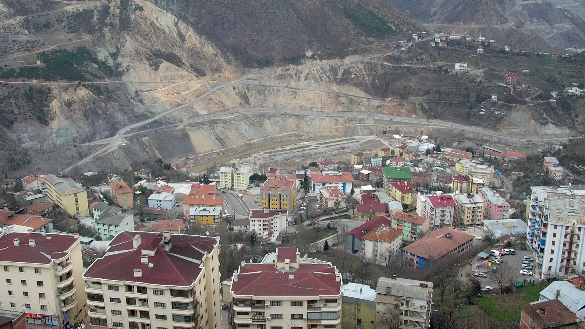 Artvin climbing a steep mountain valley below snow-streaked peaks