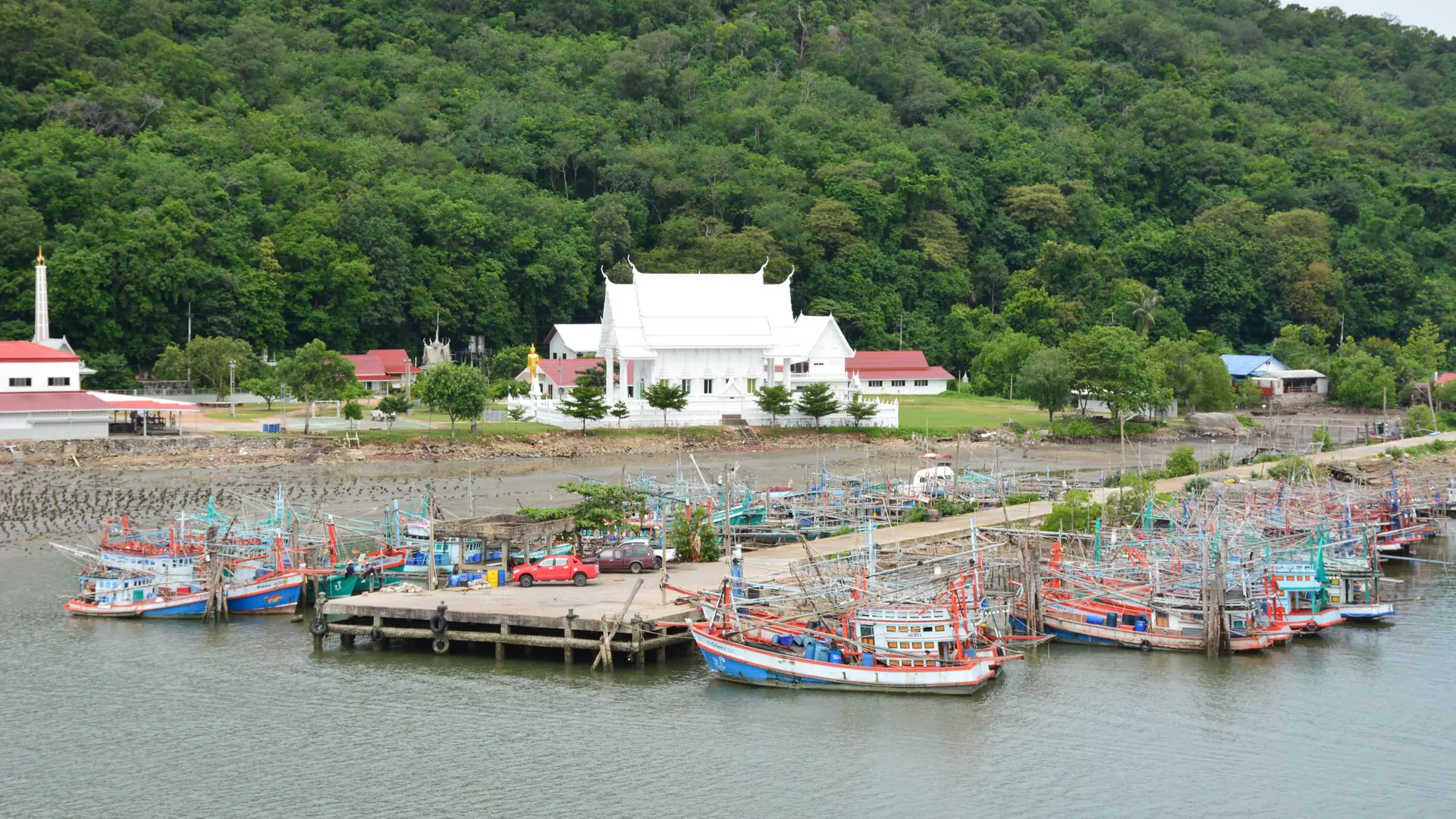 Fishing boats moored beside a riverside temple in Chanthaburi