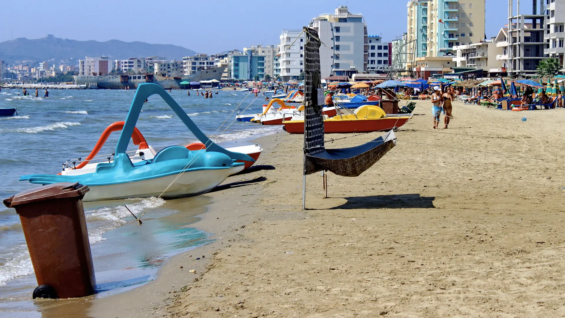 Pedal boats and umbrellas on the sandy beach at Durrës on a sunny day
