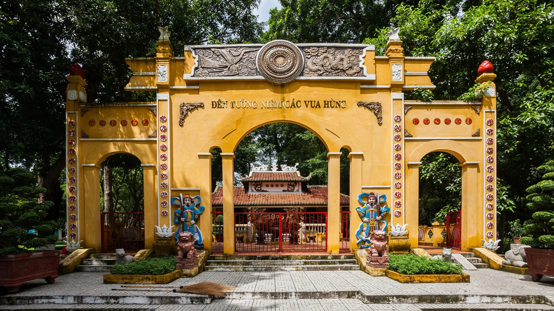 Sunlit Hung Kings memorial gate in Tao Dan Park, a wider Ho Chi Minh City scene