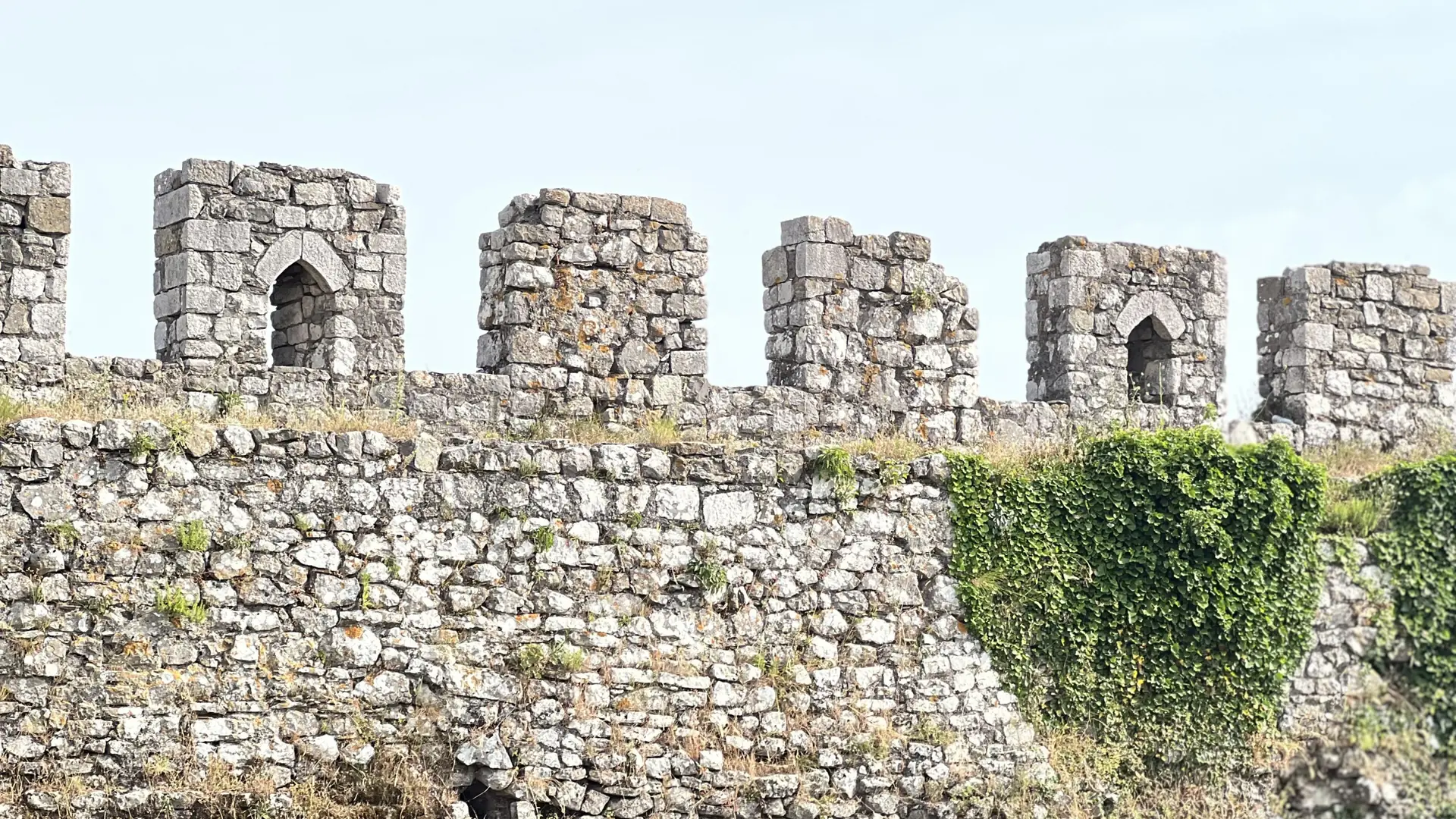 The crenellated stone walls of Rozafa Castle on the hill above Shkodër in daylight