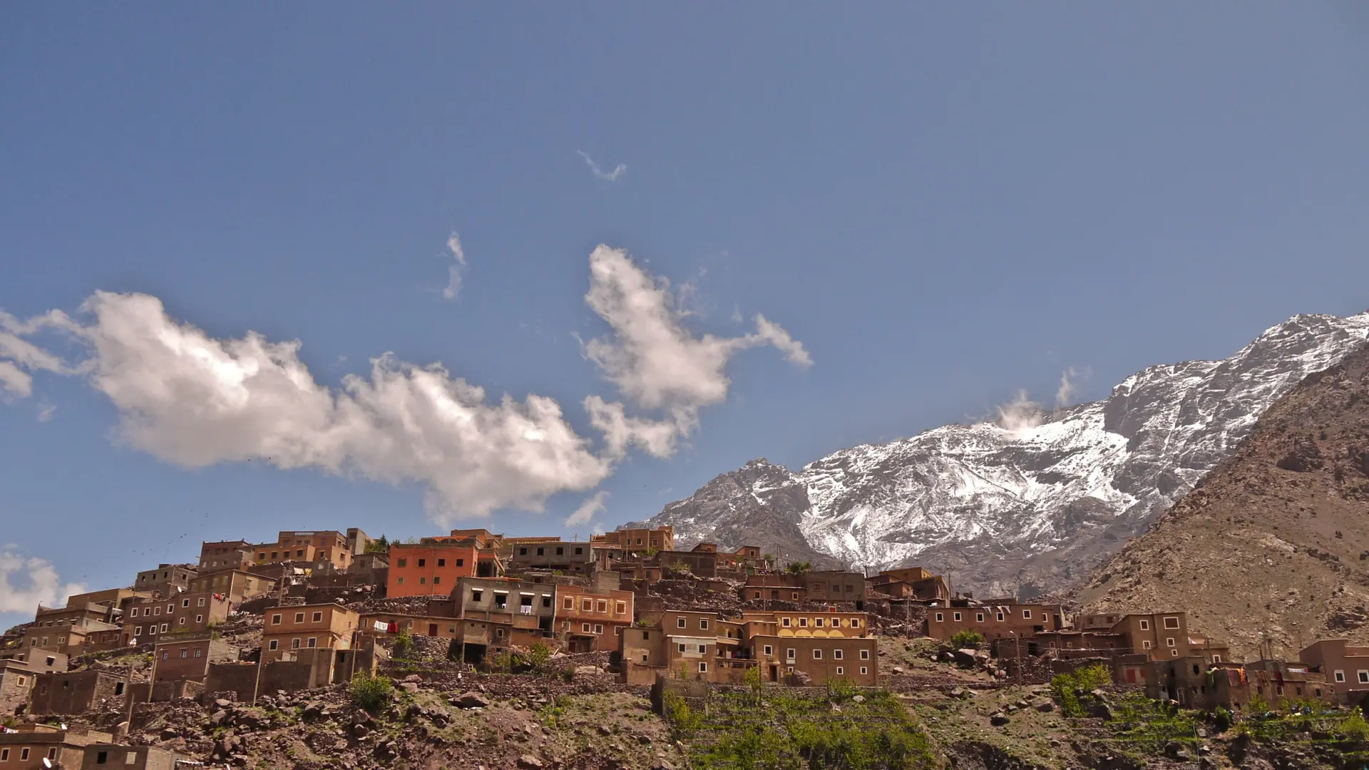 Sunlit mountain village above Imlil below snow-streaked High Atlas peaks