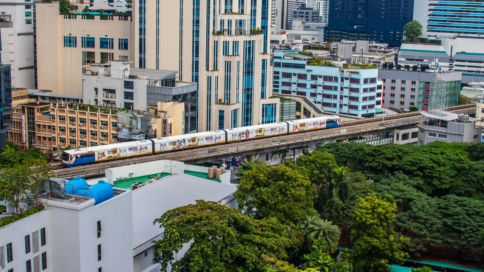 A BTS Skytrain crossing Bangkok's modern high-rise corridor