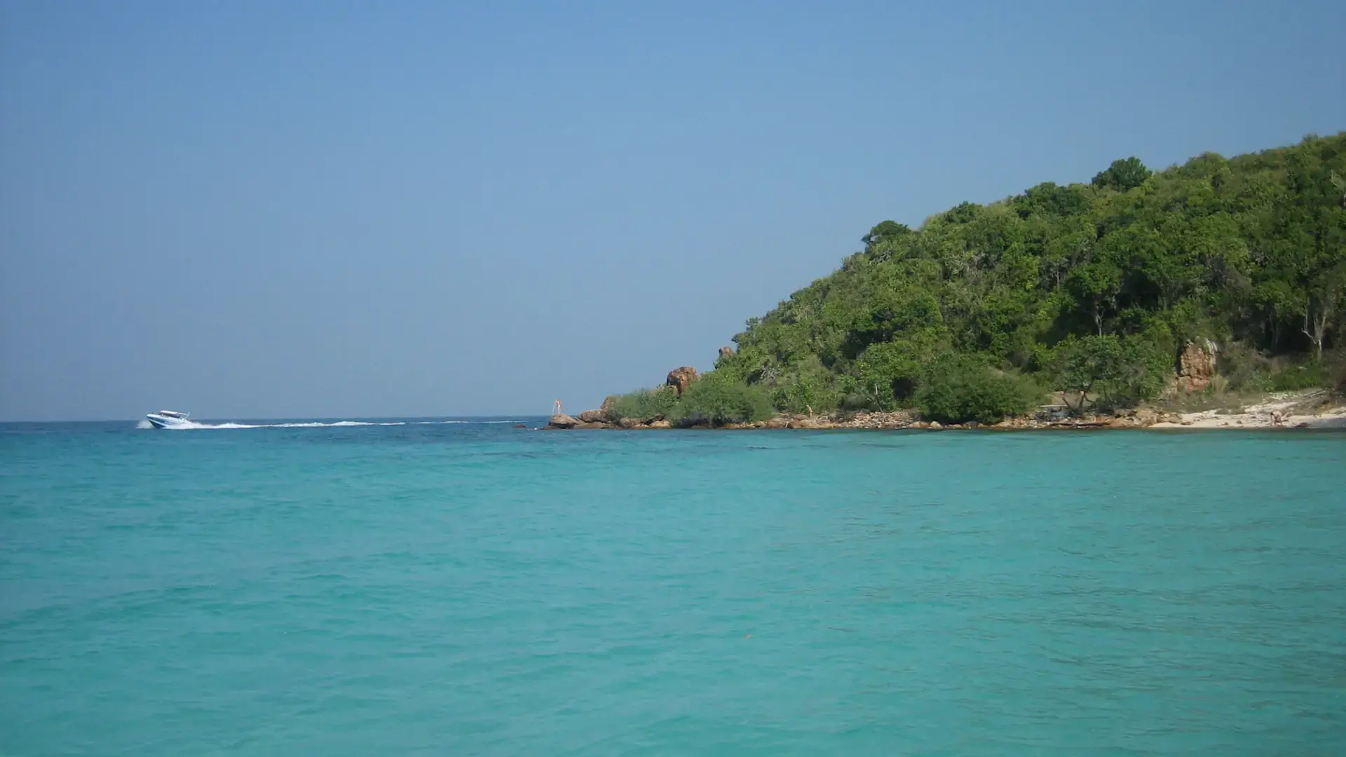 Turquoise sea and green headland beside Ta Yai Beach on Koh Larn