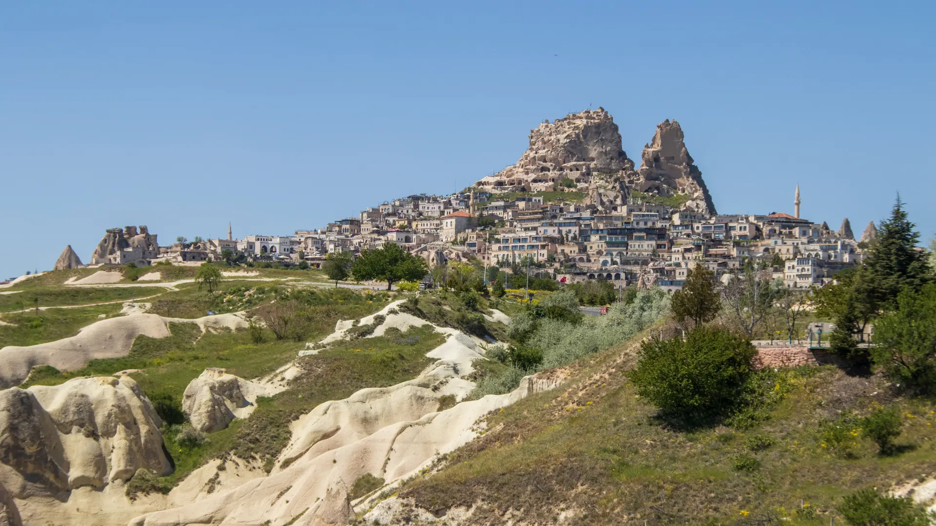 Uçhisar village and its twin rock castle above sunny Cappadocia valleys