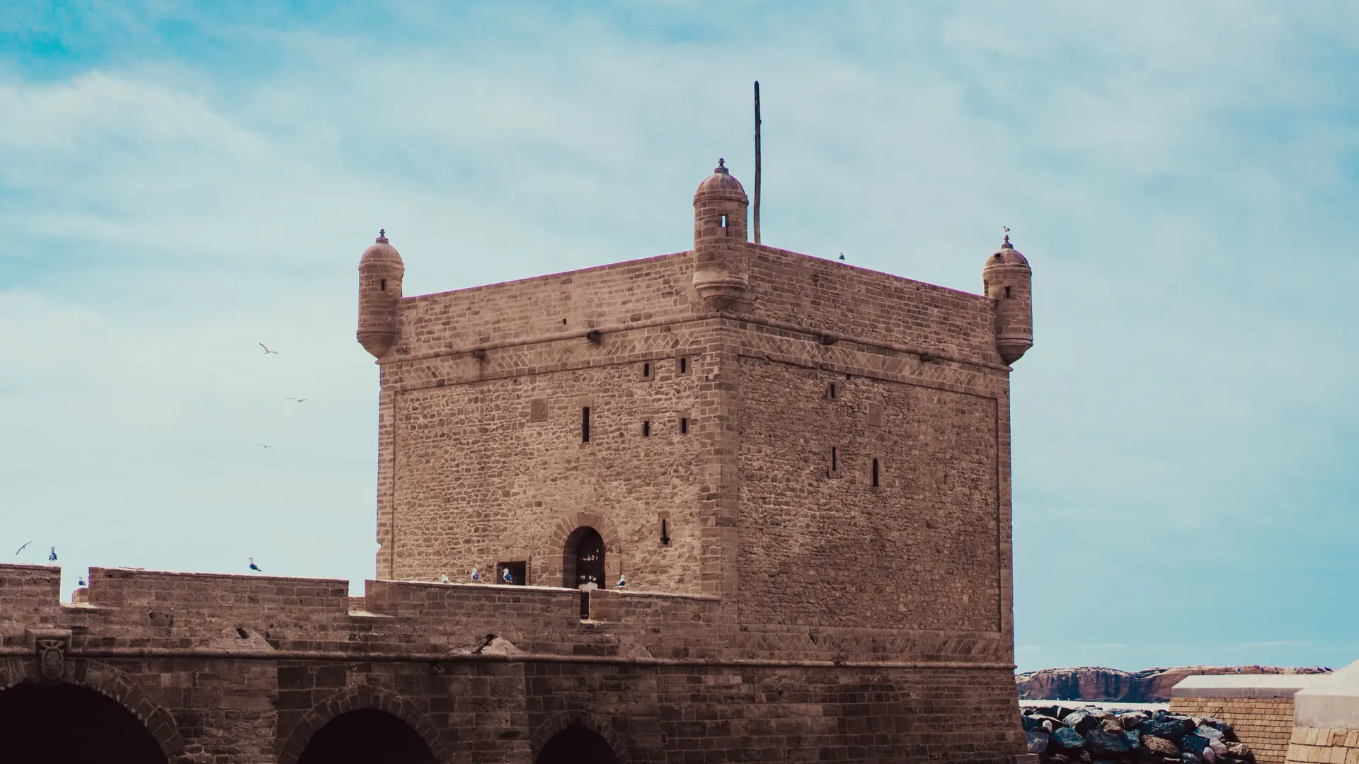 Essaouira's stone harbour fortress beneath a pale daytime sky