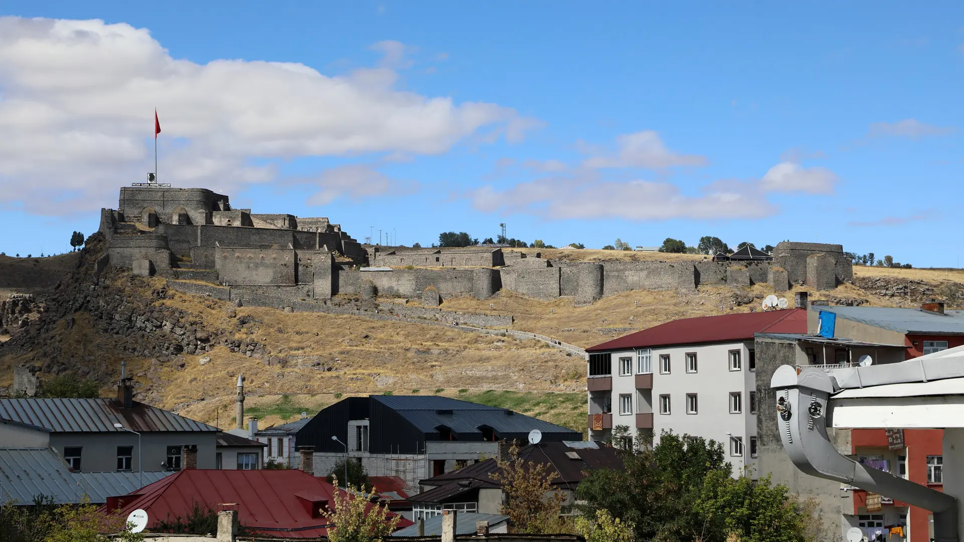 Kars Castle above the city’s red-roofed houses beneath a bright blue sky