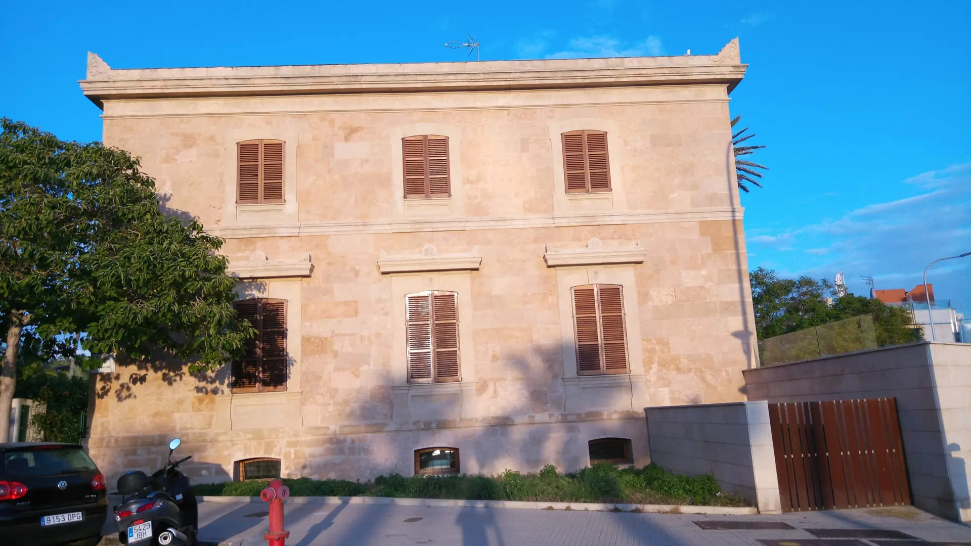 Sunlit stone façade and shuttered windows of Can Salas–Sa Petrolera on Palma’s Portixol–Molinar coast