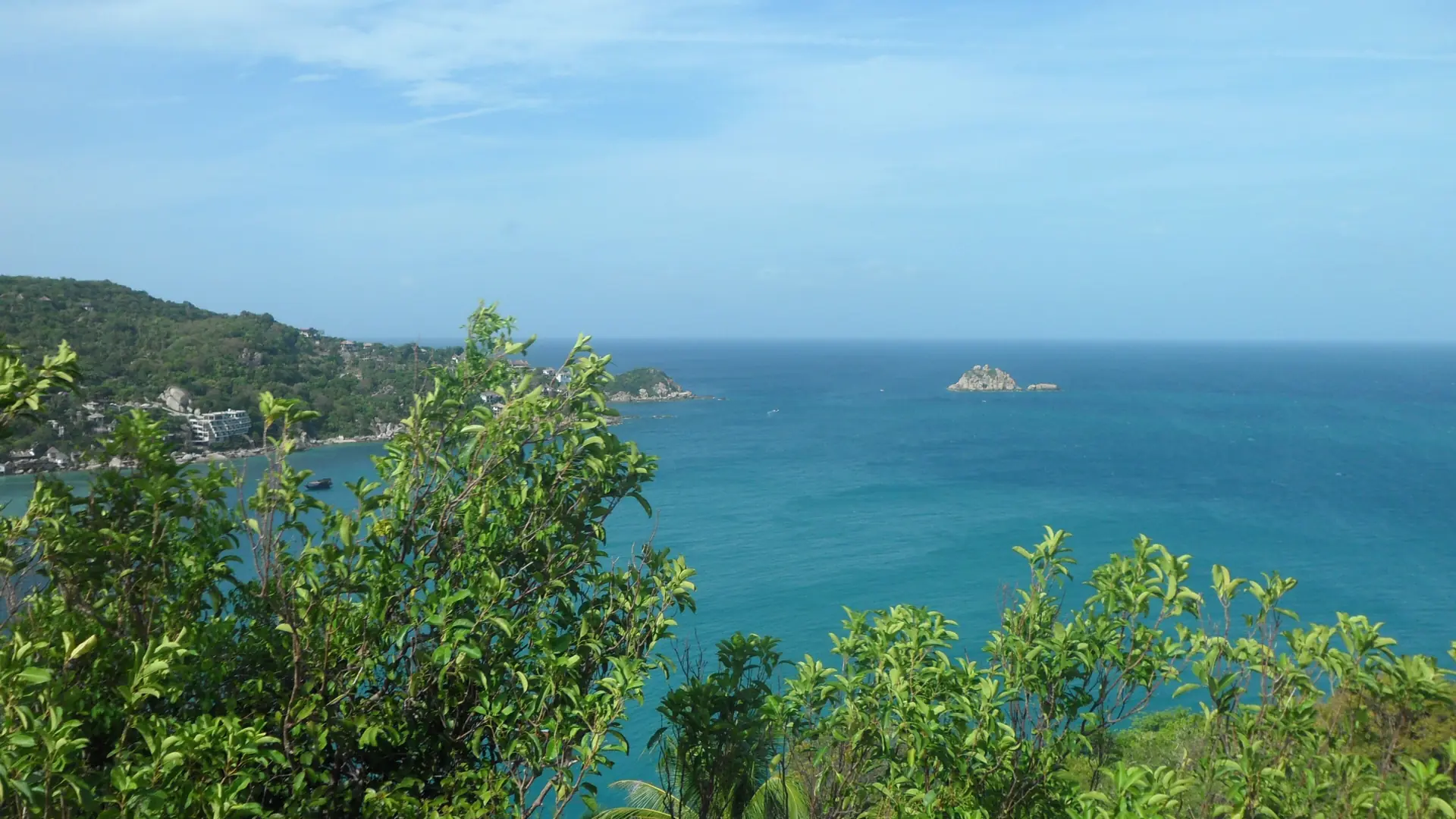 Daylight hilltop view over the green coastline of Koh Tao and the sea