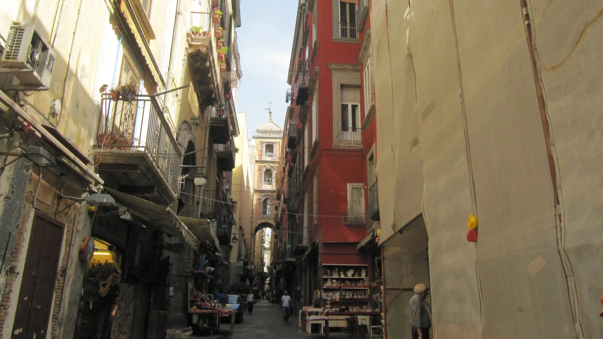 a sunlit lane in Naples' historic centre lined with nativity-figurine shops