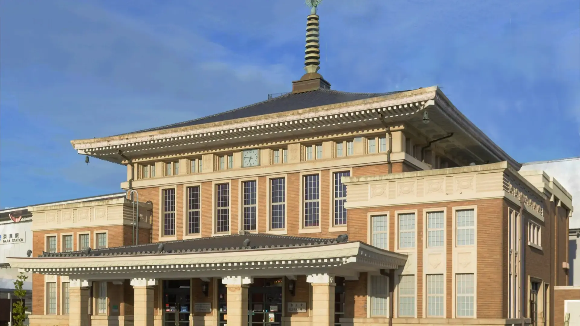 JR Nara Station's historic brick frontage beneath a vivid blue sky