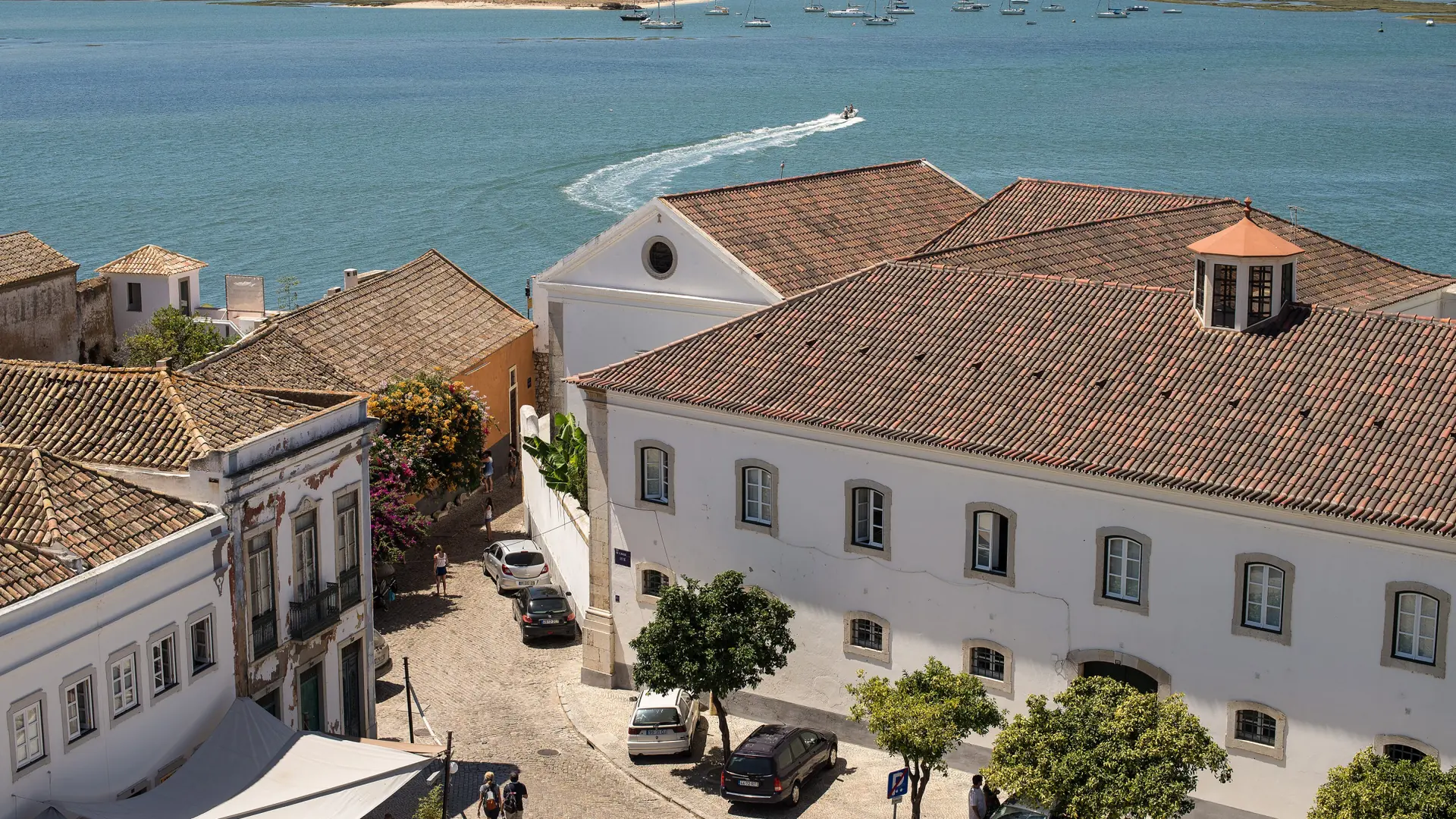 Faro’s historic white buildings and tiled roofs overlooking Ria Formosa in daylight