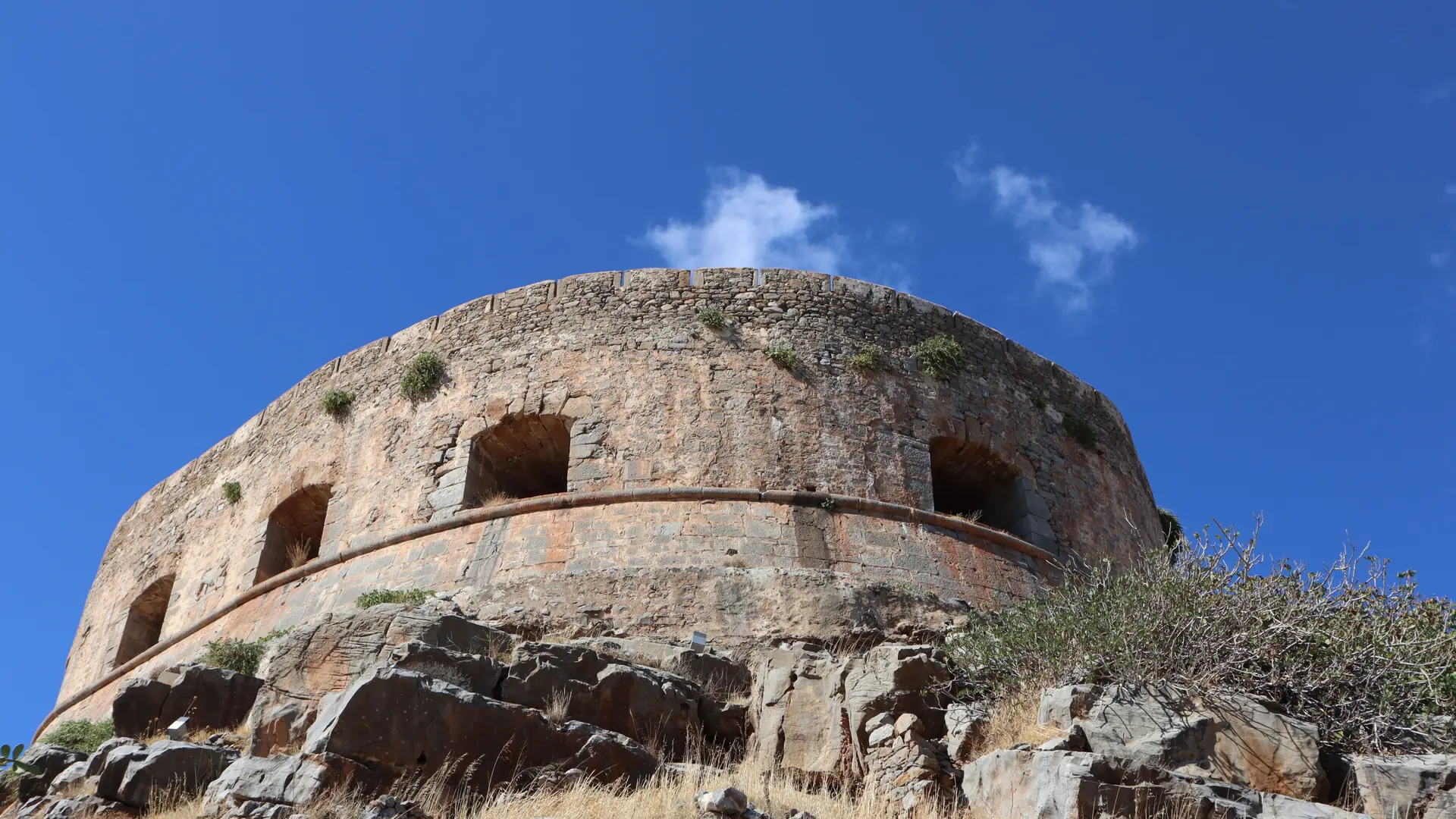 The circular stone bastion of Rethymno's Fortezza against a deep blue sky