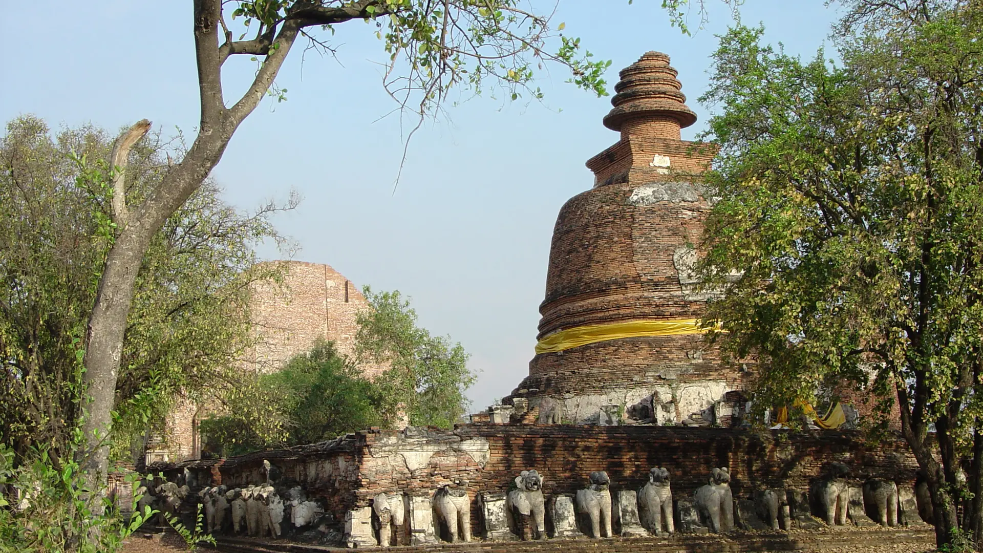 Sunlit elephant sculptures around the chedi at Wat Maheyong, east of Ayutthaya station