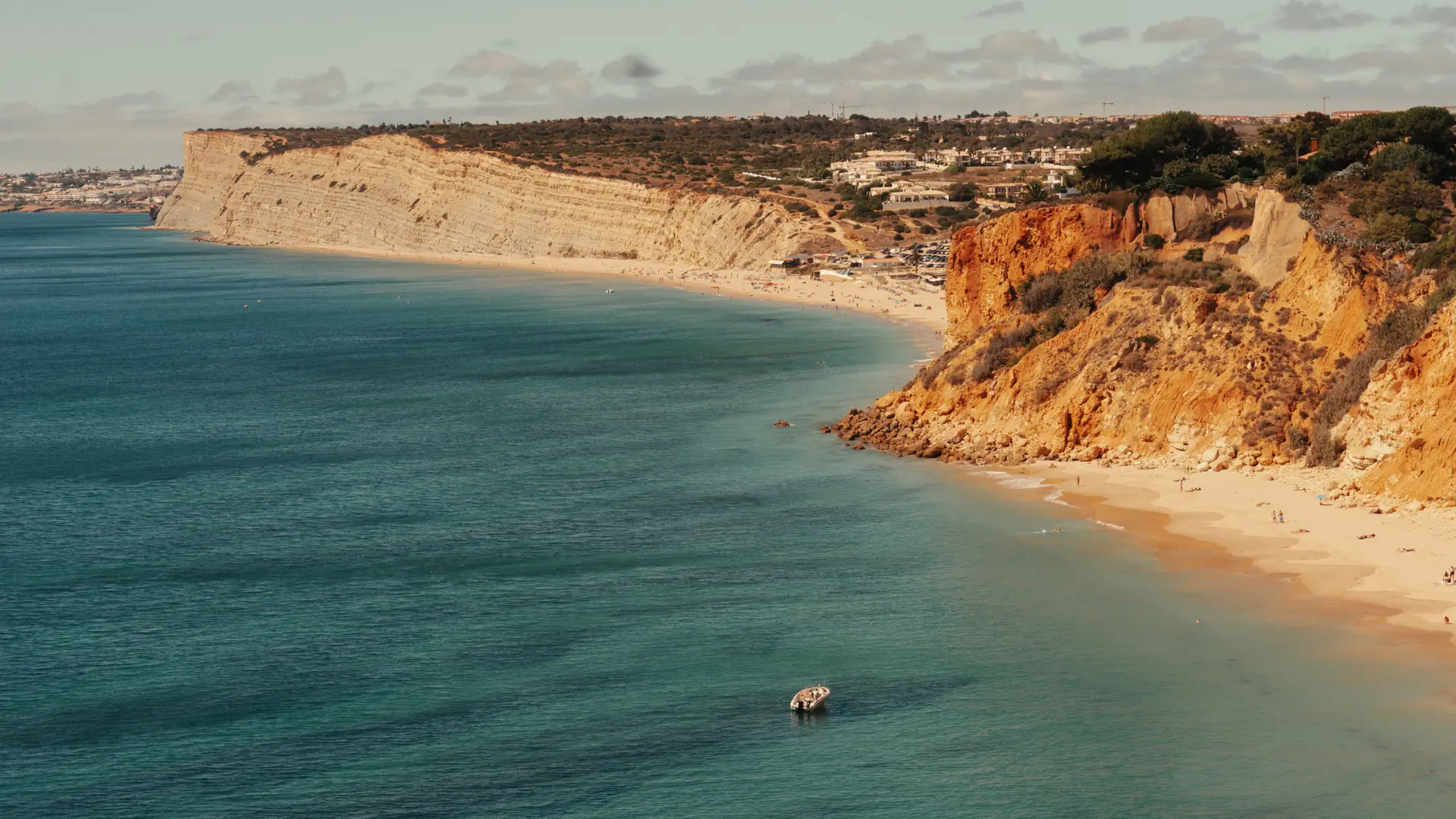 Sunny Lagos coastline with golden cliffs, white town and Atlantic water
