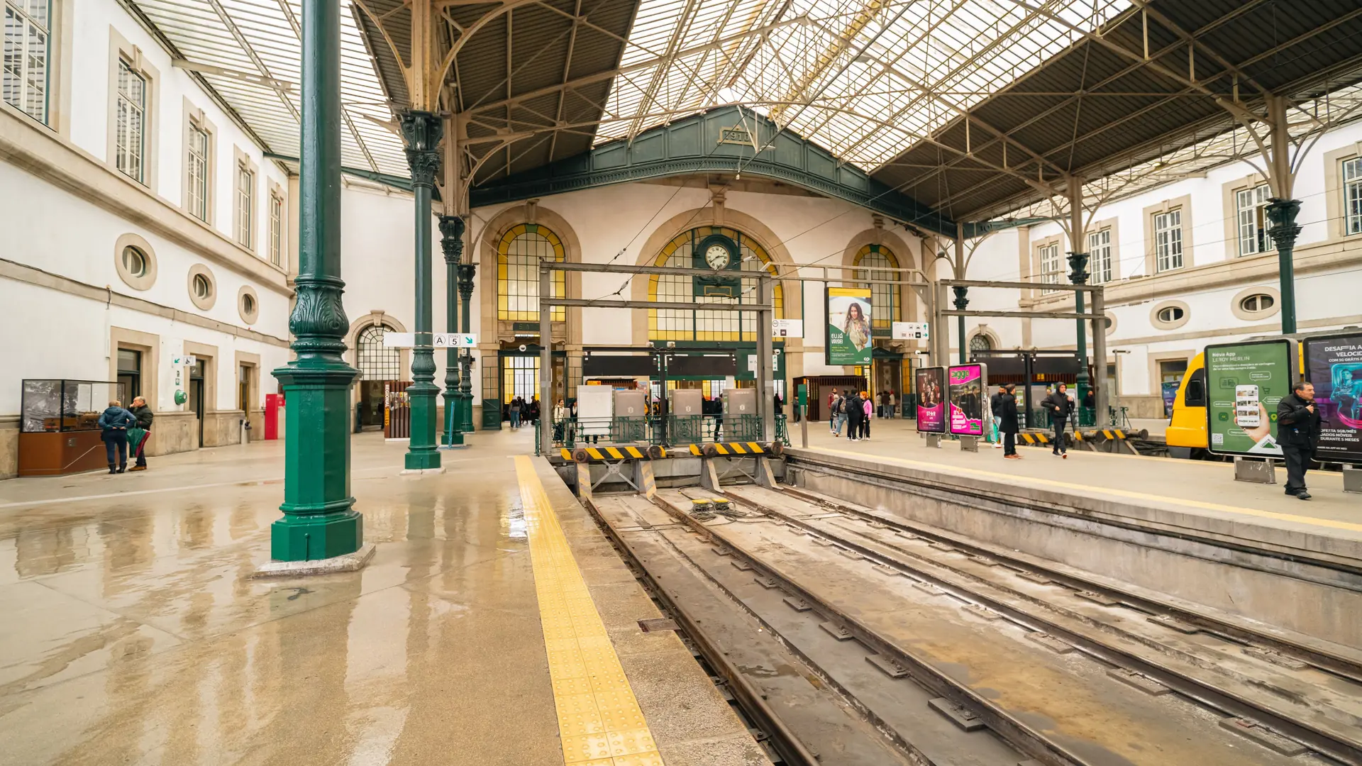 Daylit platforms and green iron columns at São Bento railway station in Porto