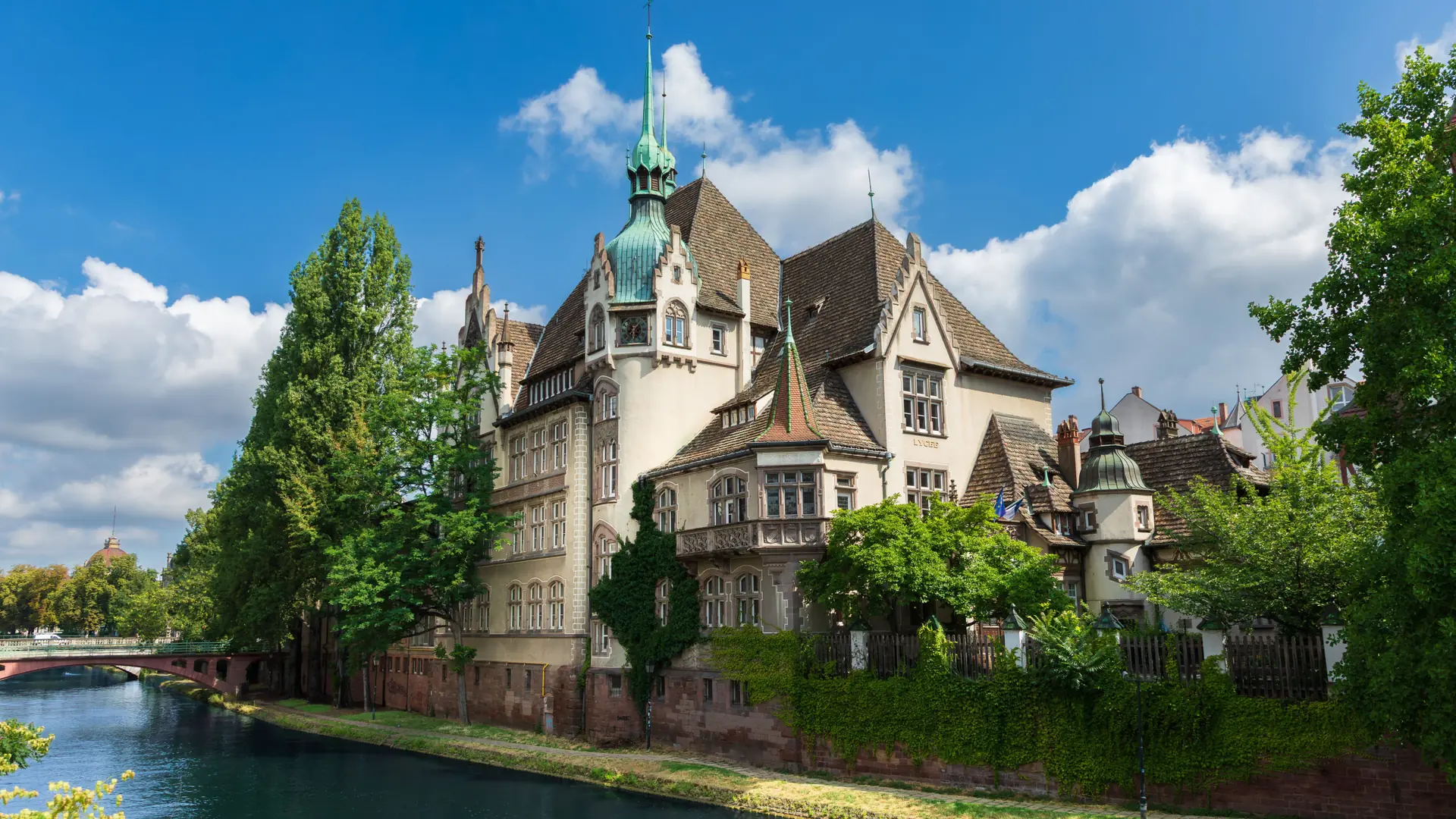 The riverside Lycée des Pontonniers in sunny Strasbourg, shown as a wider city scene