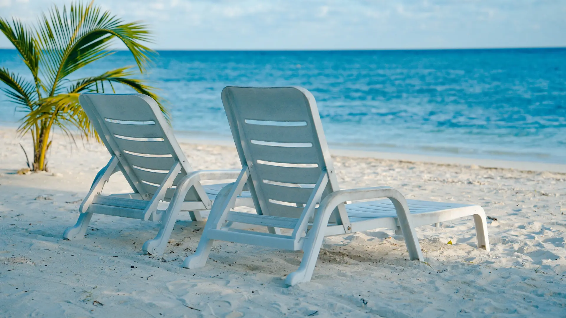 Two loungers beside the visitor beach on neighbouring Himmafushi island
