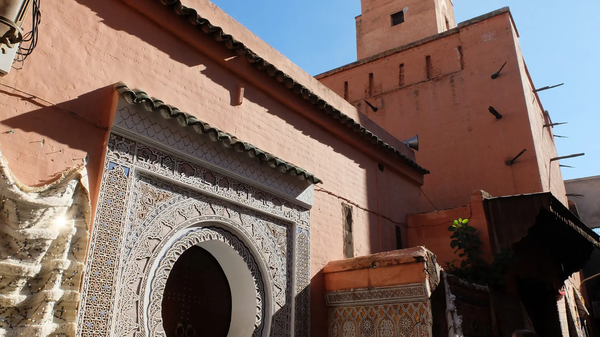 Carved Mouassine Mosque entrance with its short square minaret in Marrakech