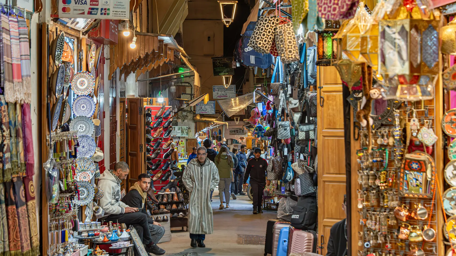 Colourful market lane in Fez medina with shoppers in daylight
