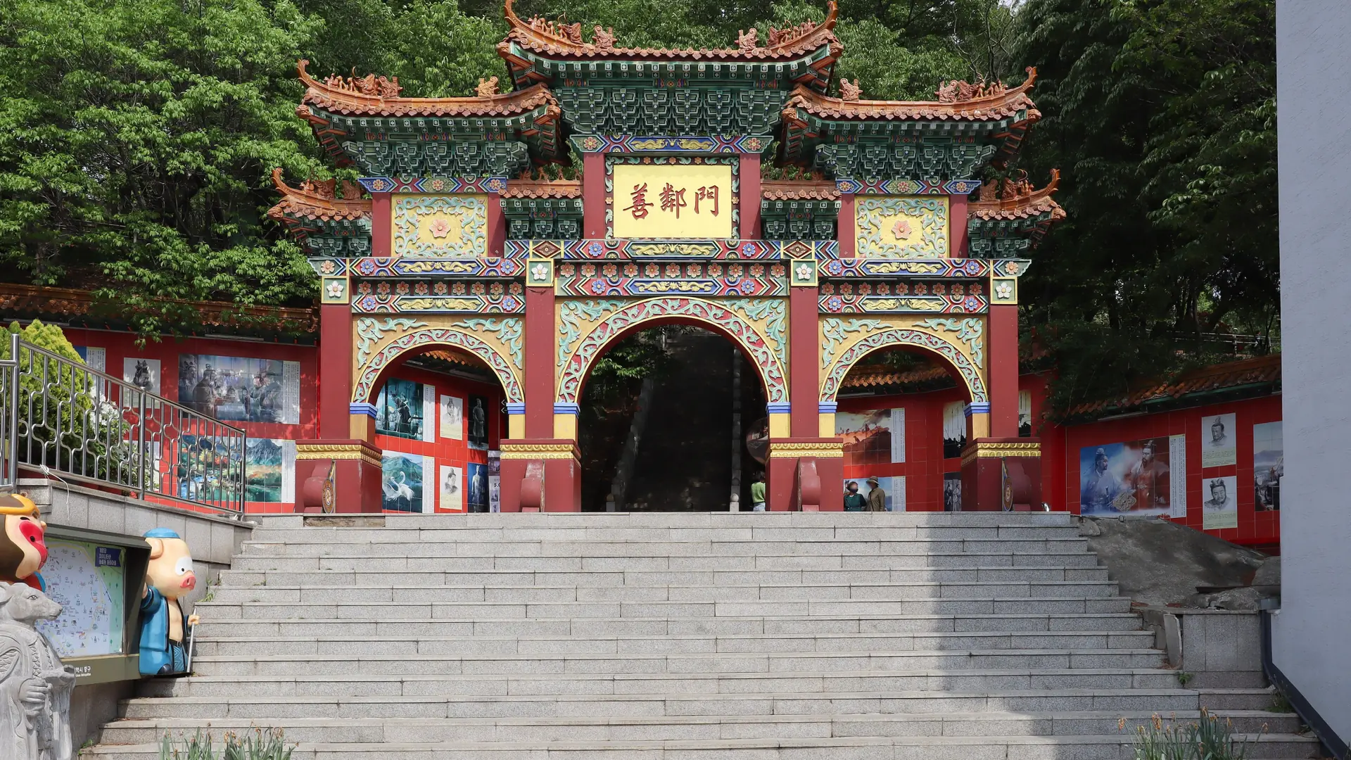The ornate Seonrinmun Gate above steps in Incheon Chinatown, surrounded by leafy trees