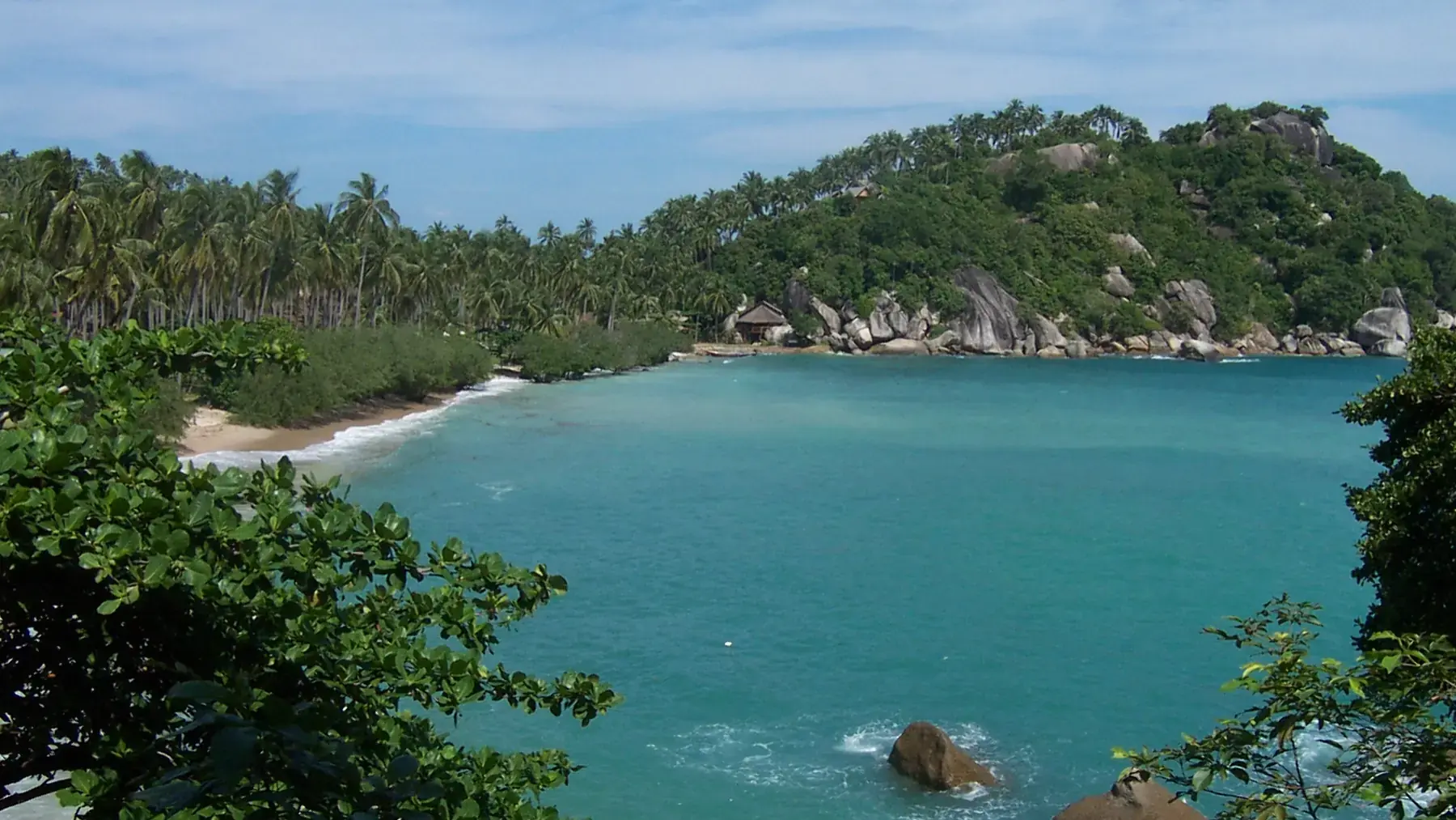 A forested Haad Tien bay with granite boulders on Koh Phangan