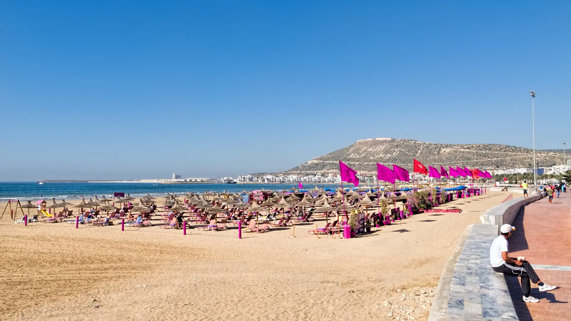 Sunlit Agadir beach, promenade and Oufella hill beside the Atlantic bay
