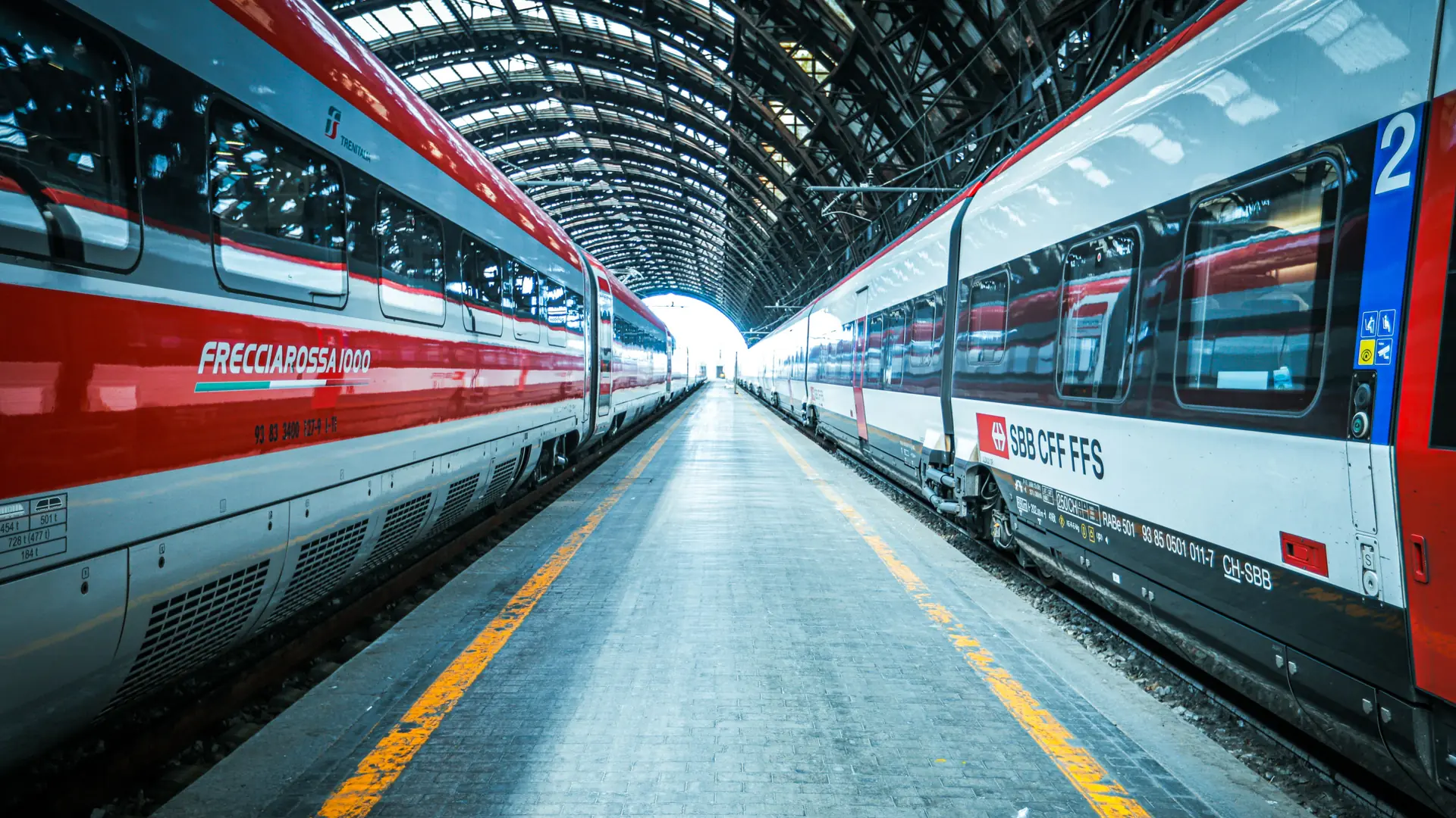 A modern high-speed train arriving at a large Italian city station