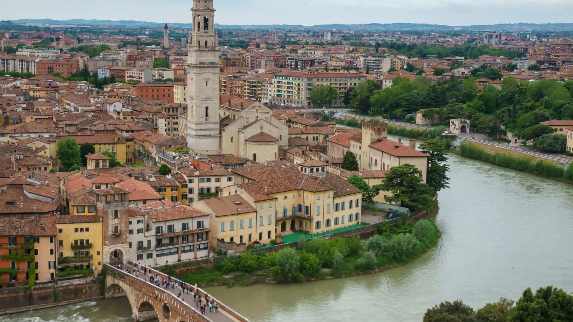 A bright wide view of Verona’s river, bridges, tiled roofs and historic centre