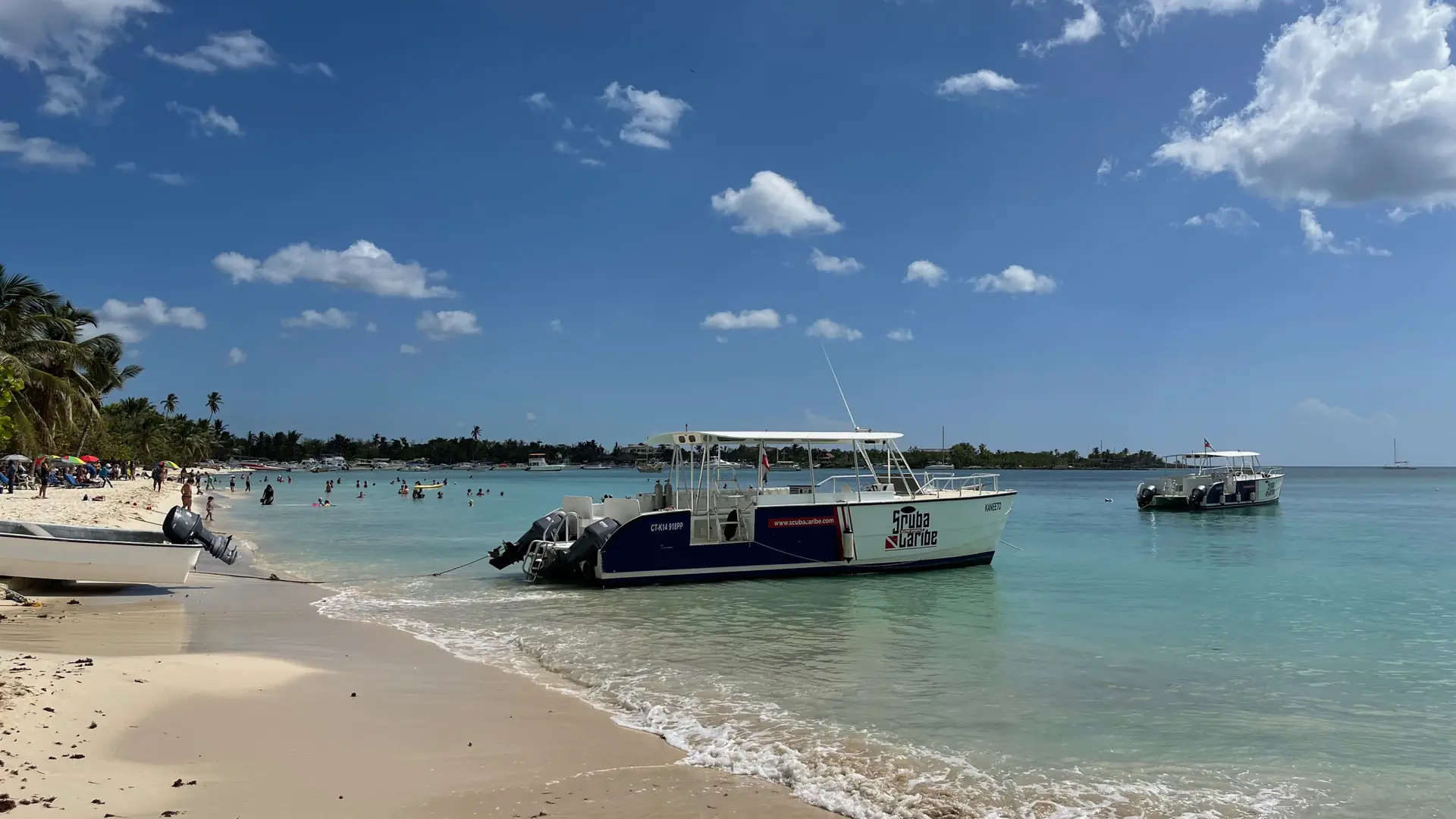 Excursion boat in clear water beside sunny Playa Bayahíbe shore