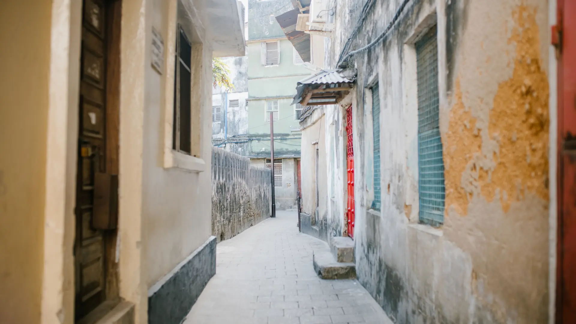 Daylit narrow coral-stone lane in historic Stone Town, Zanzibar City