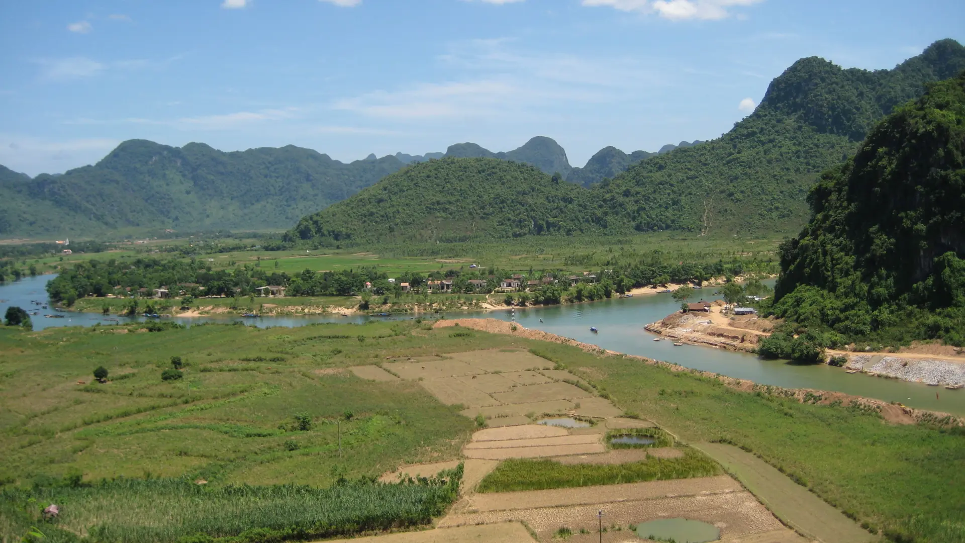 Fields, village roofs and a winding river in the wider Phong Nha-Ke Bang landscape, not a verified Cu Nam property