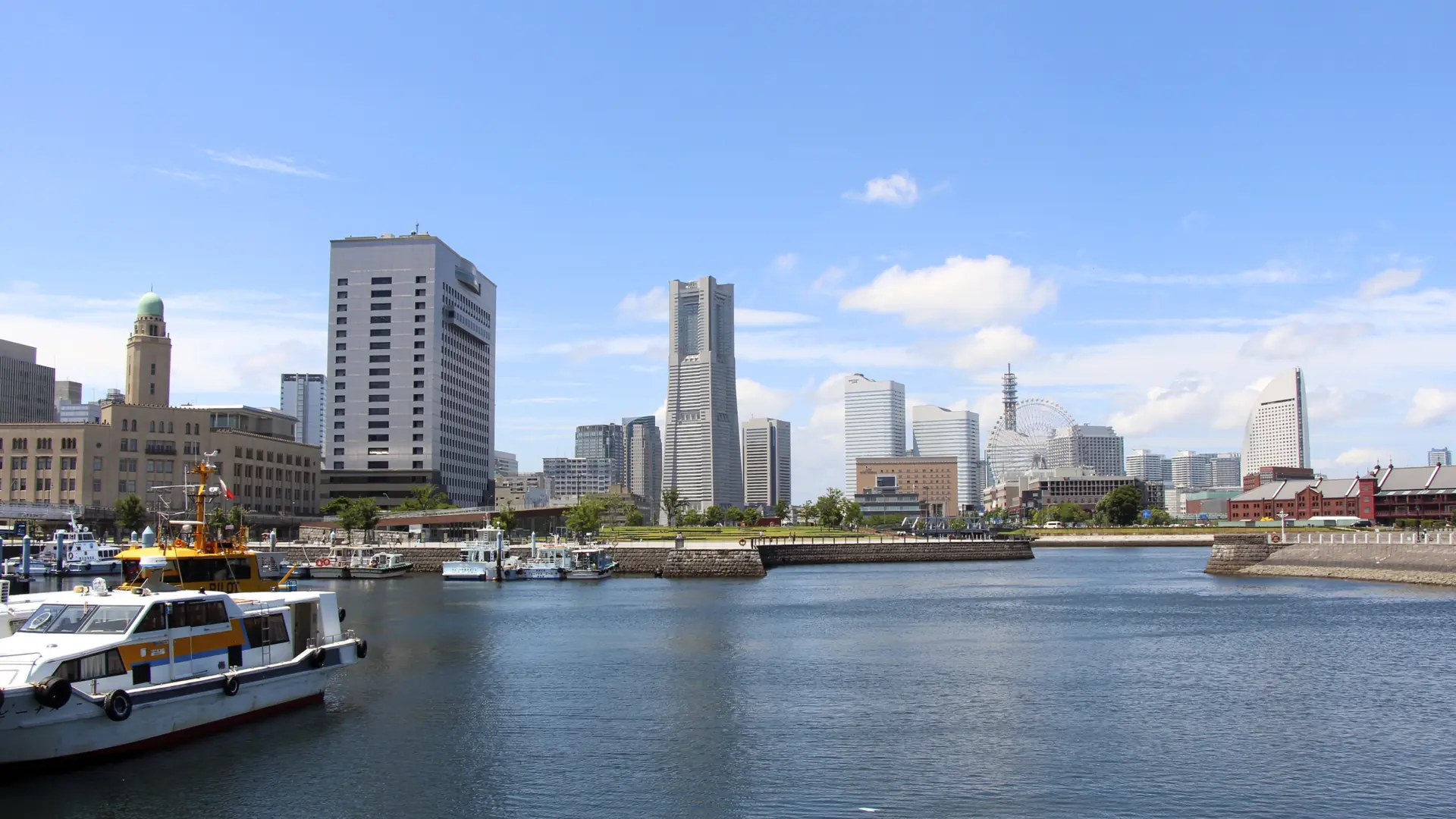 Boats in Yokohama’s harbour beneath the Customs House tower and the Minato Mirai skyline.