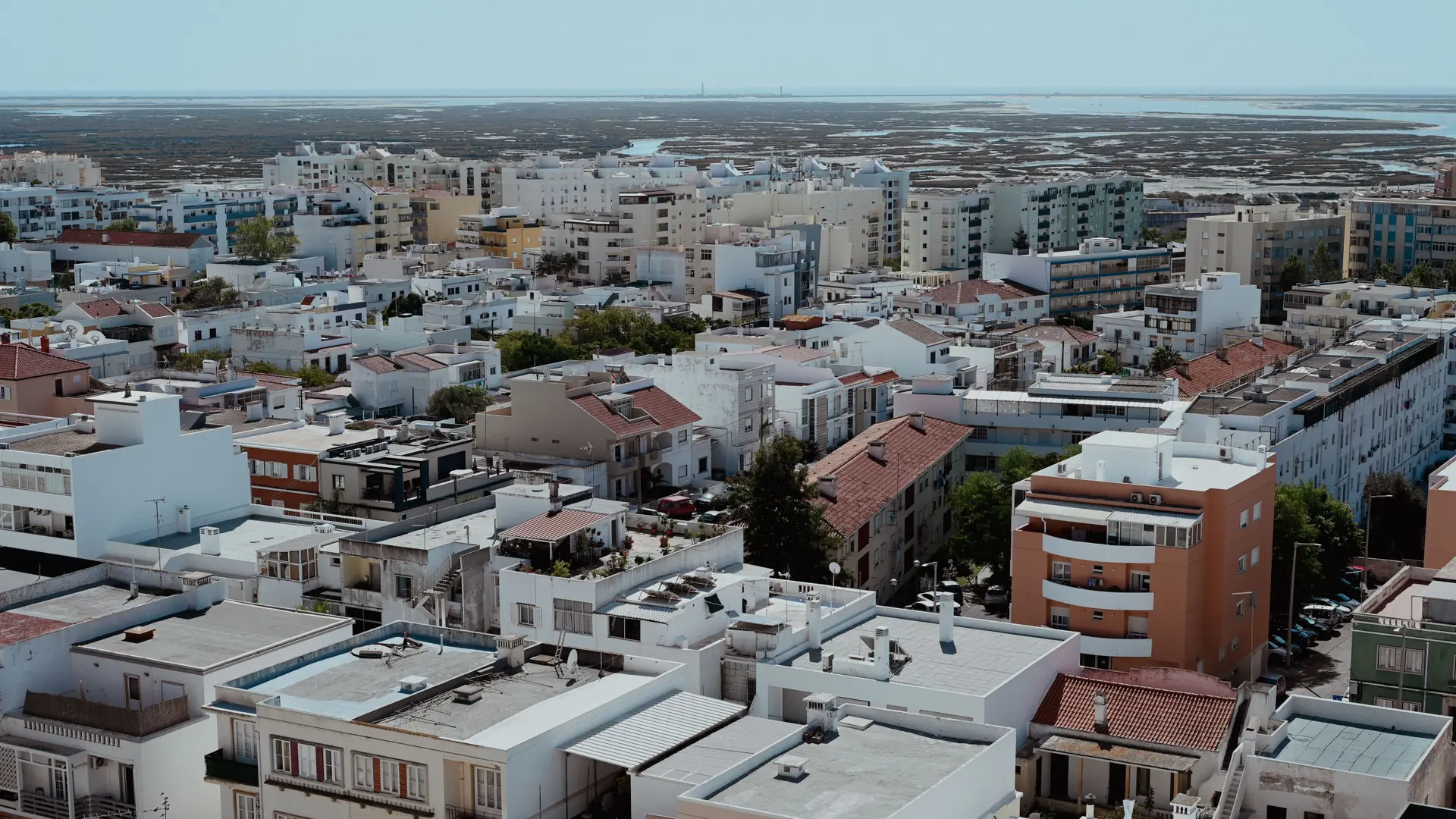 Sunny aerial cityscape of central Faro with low-rise roofs and apartment blocks