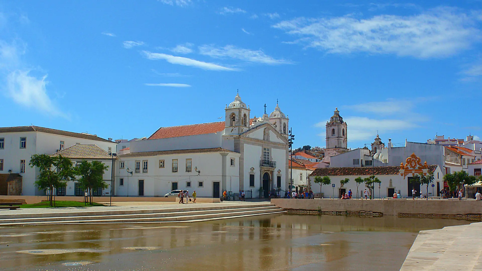 Santa Maria church and the historic buildings of Praça do Infante in Lagos under a blue sky