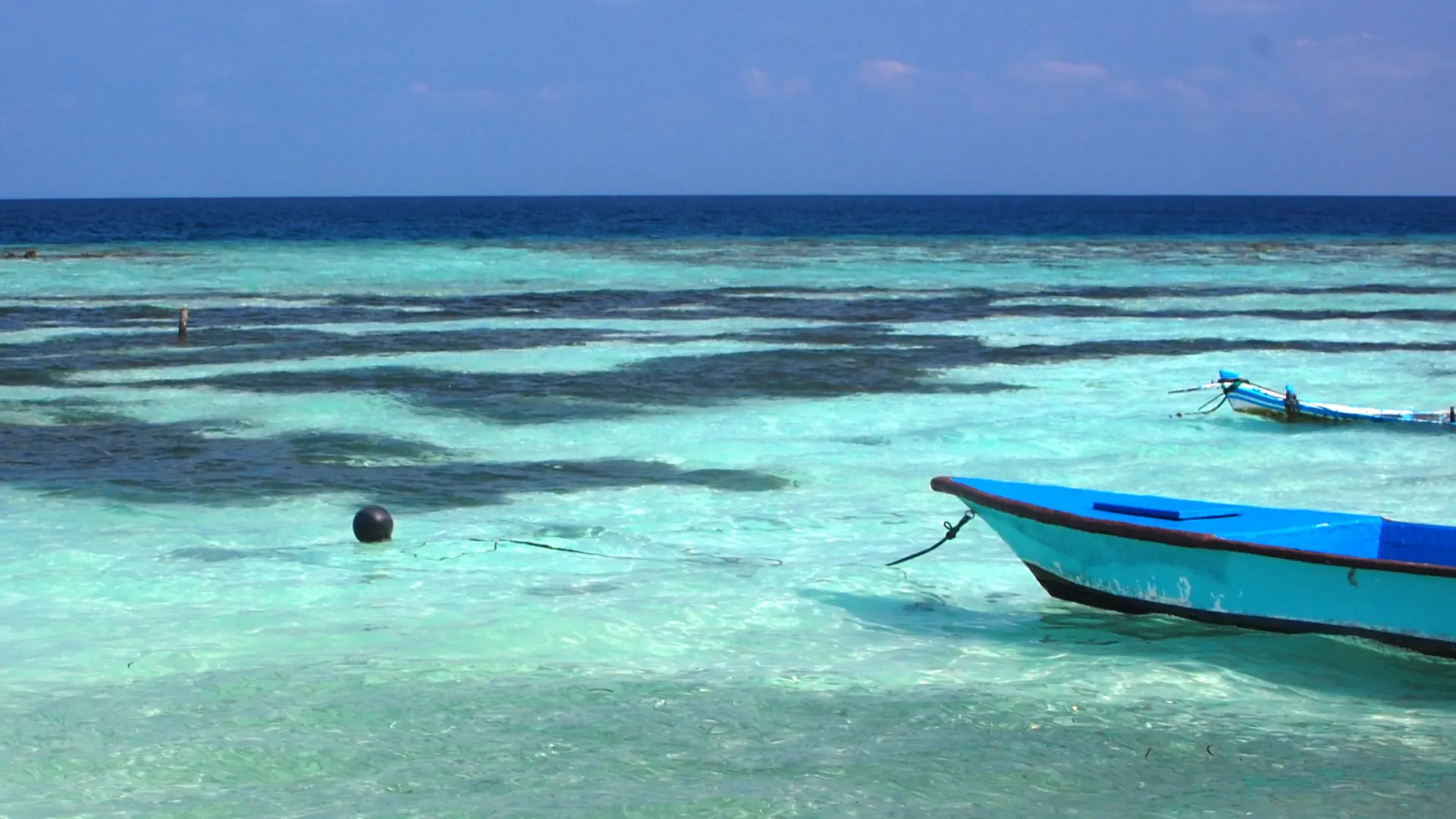 Turquoise lagoon and small boats just off Maafushi island