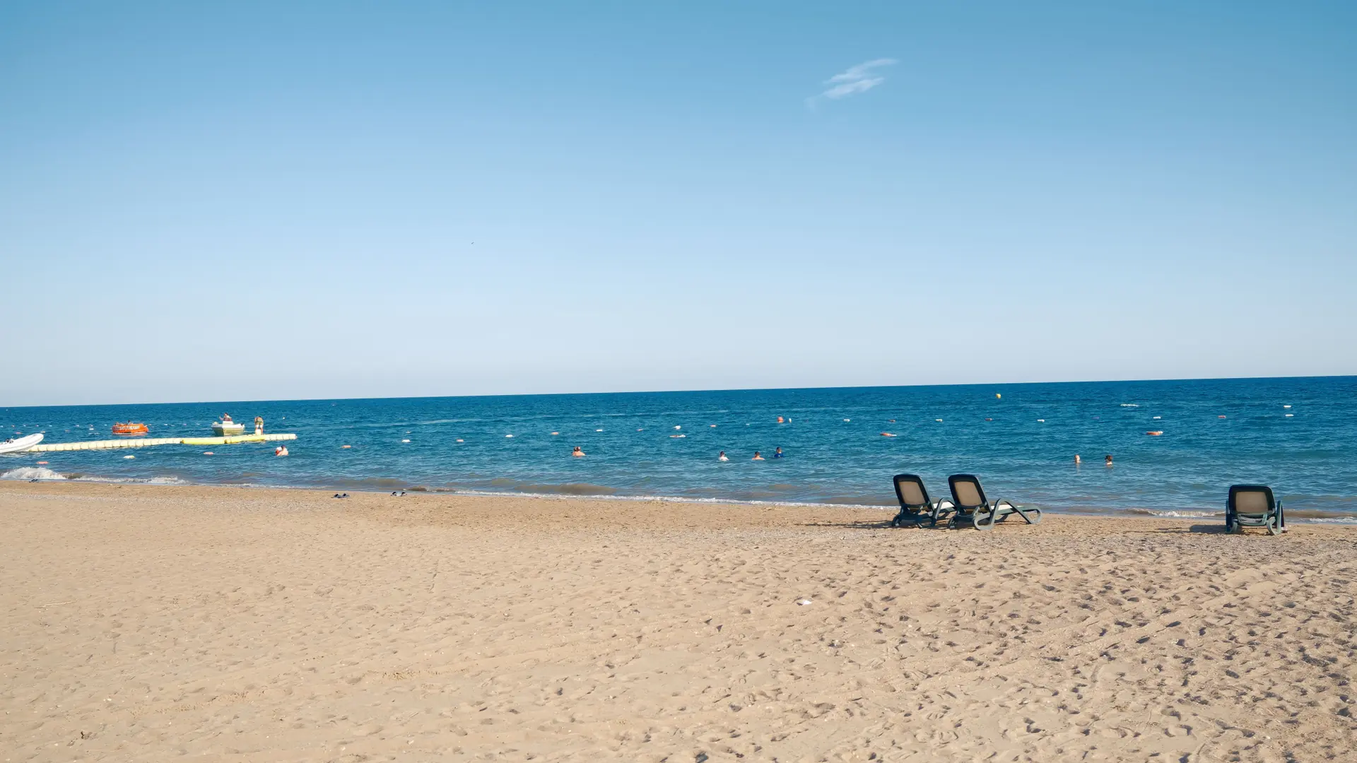 Bright sandy Mediterranean beach in Antalya with clear blue water and open sky