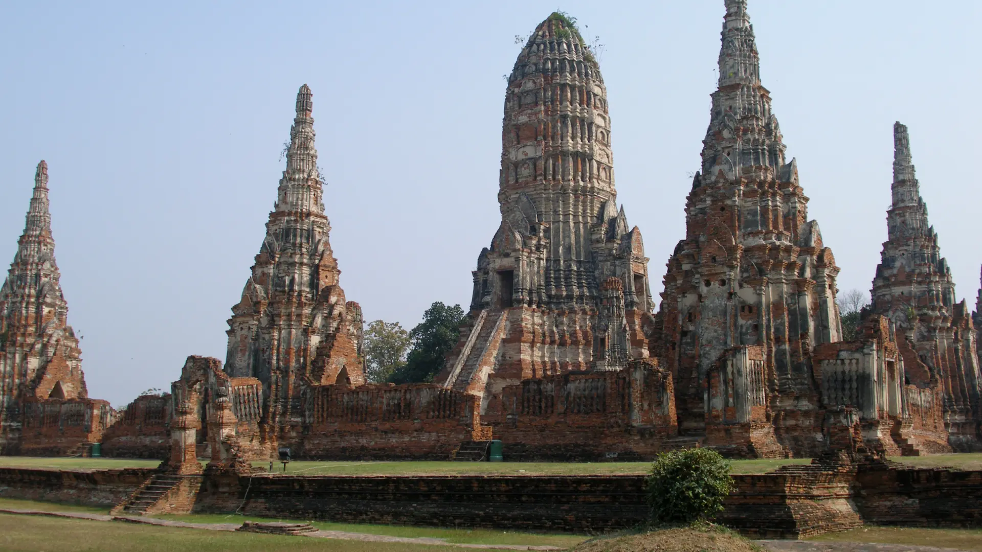Brick stupas and cloisters at Wat Chaiwatthanaram in warm daylight