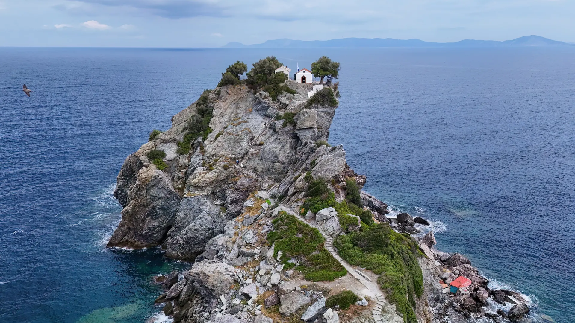 Agios Ioannis Kastri chapel perched above the Aegean Sea on a rocky Skopelos islet
