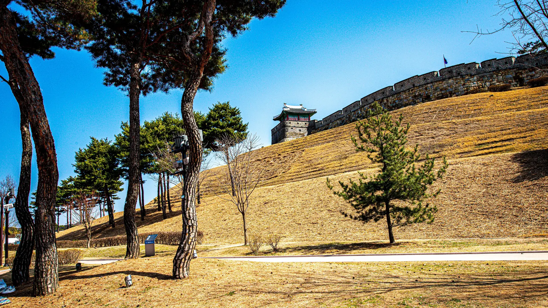 Hwaseong Fortress's stone walls and watchtowers in Suwon under a bright blue sky