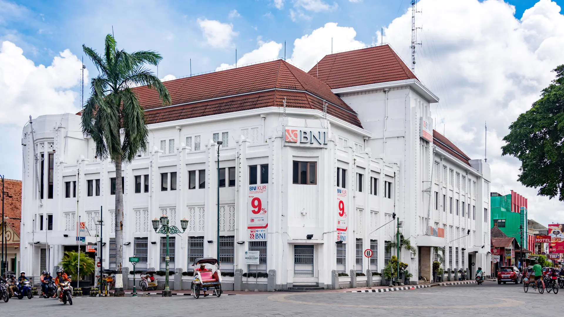 Historic white BNI building and horse carriage at a street corner near Yogyakarta’s palace
