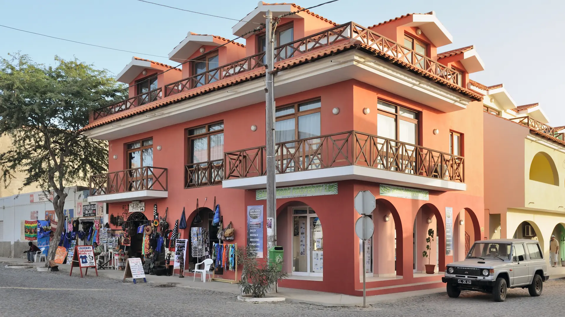 Sunlit pink corner house on a street in Santa Maria, Sal