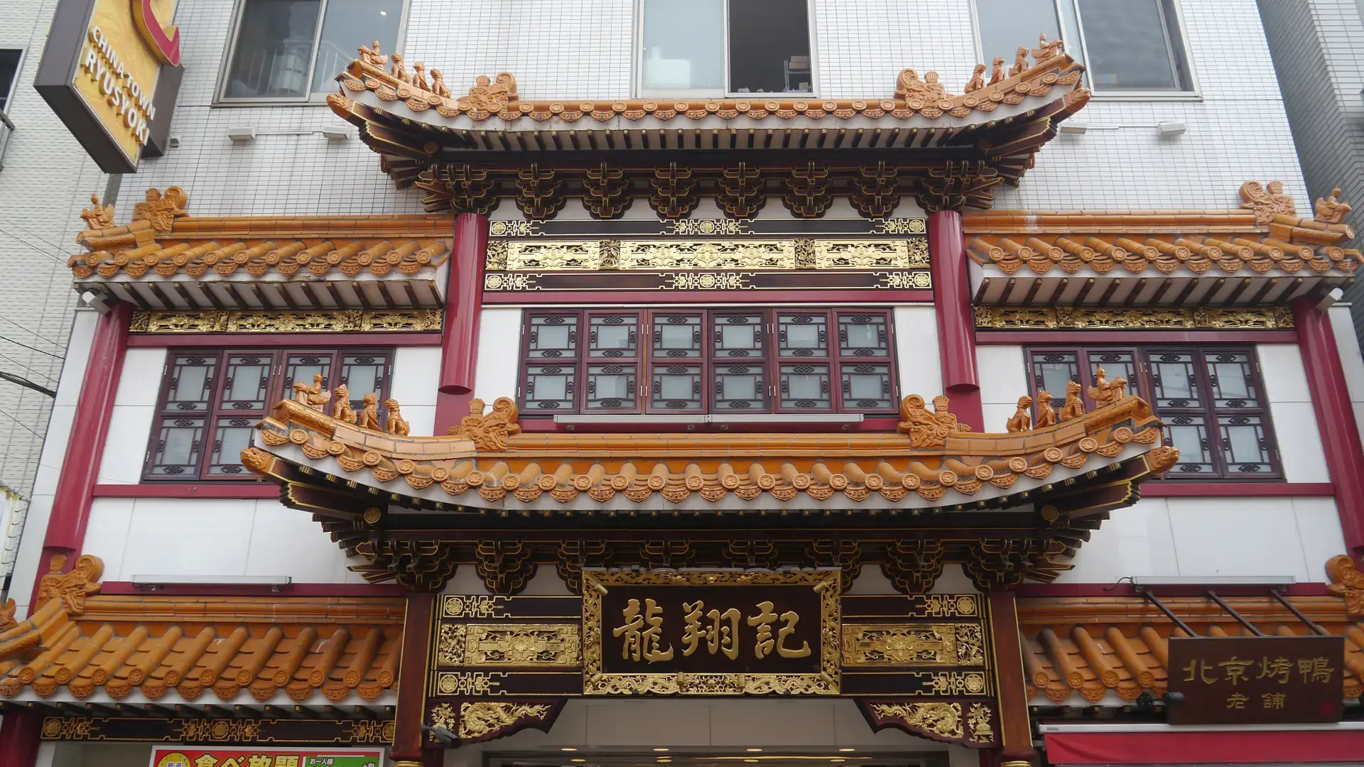 ornate Yokohama Chinatown gate beneath blue sky on a colourful pedestrian street