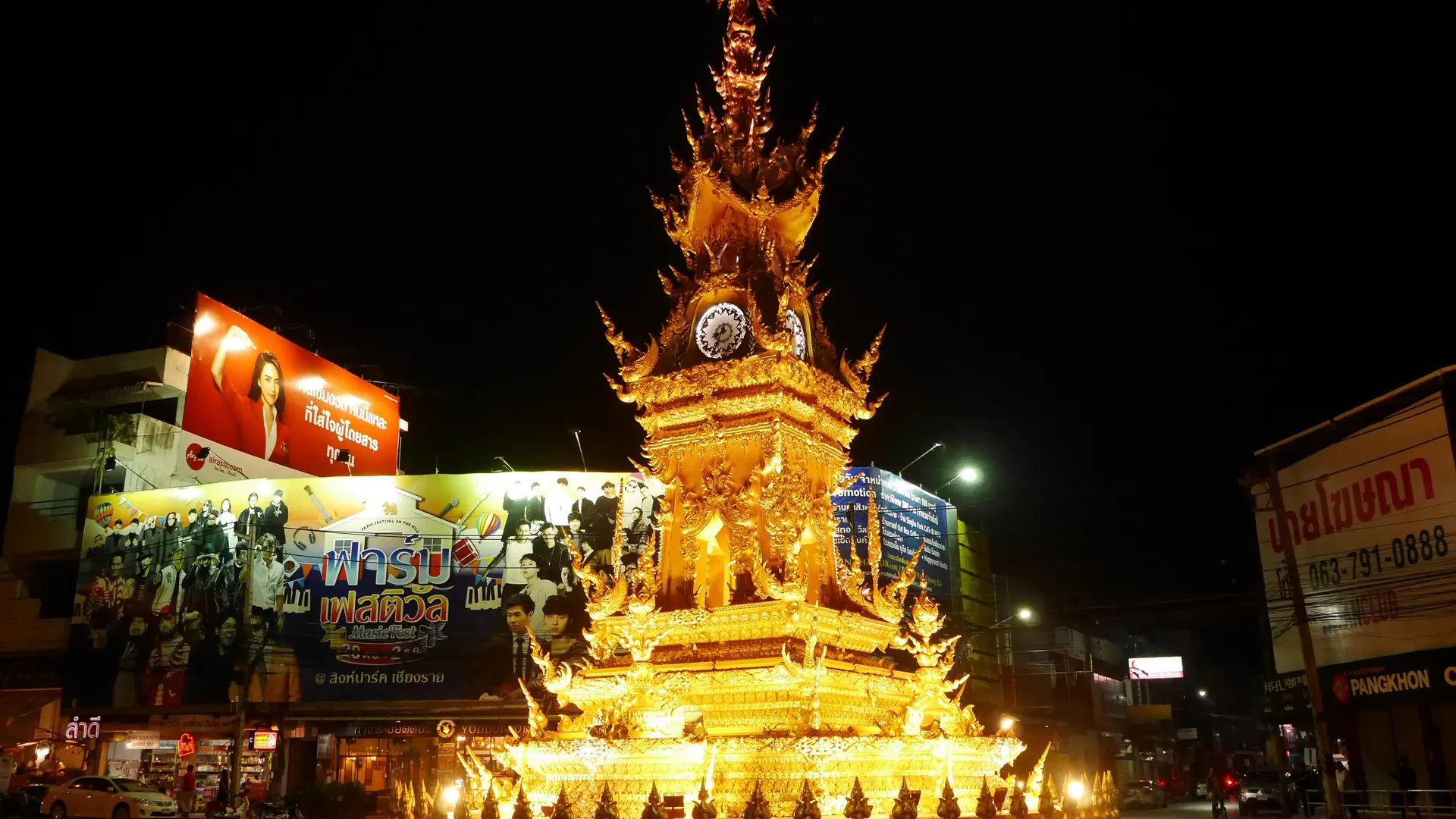 Chiang Rai's golden Clock Tower illuminated above the night street