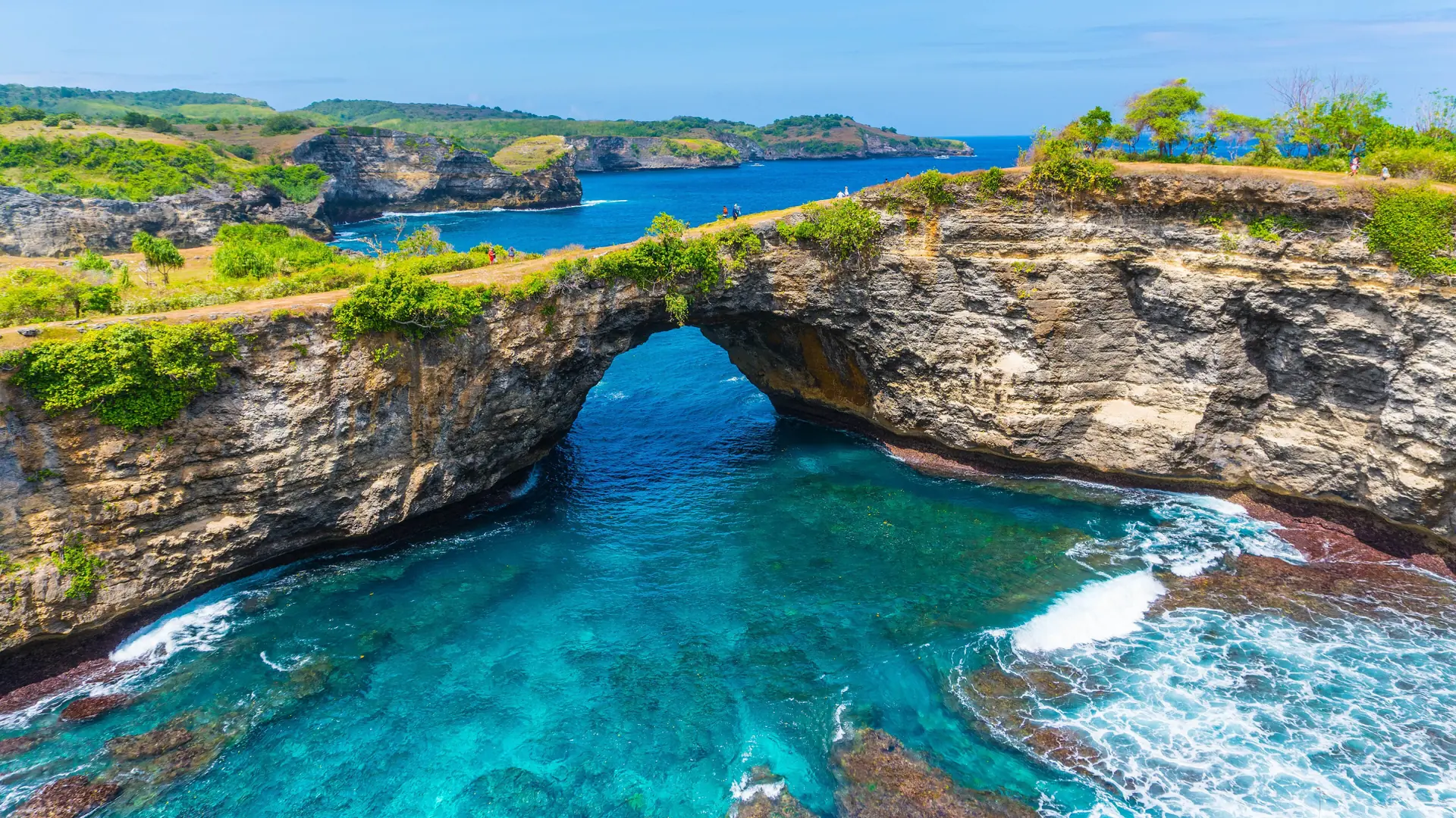 The limestone arch and turquoise inlet at Broken Beach on the wider Nusa Penida coast