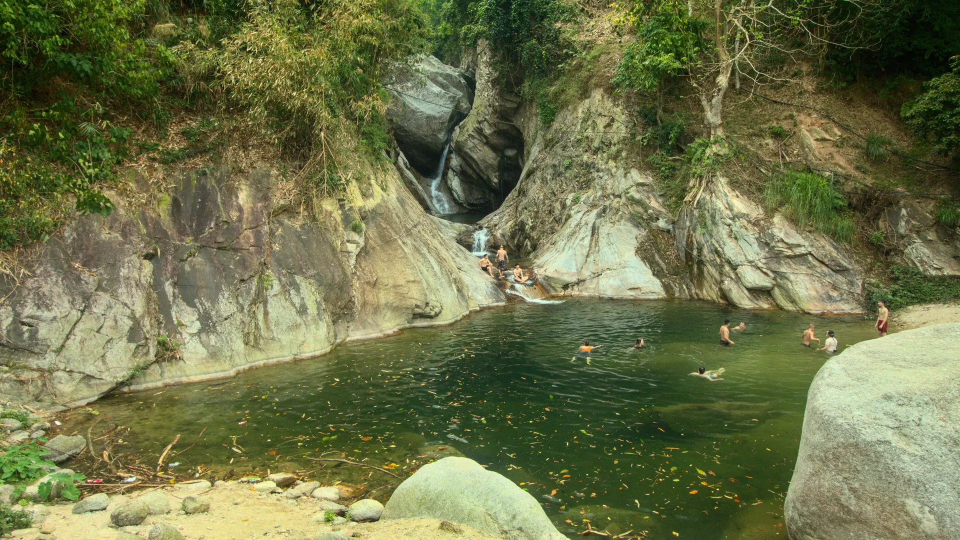 A waterfall and sunlit rocks at Ha Thanh outside Ha Giang city