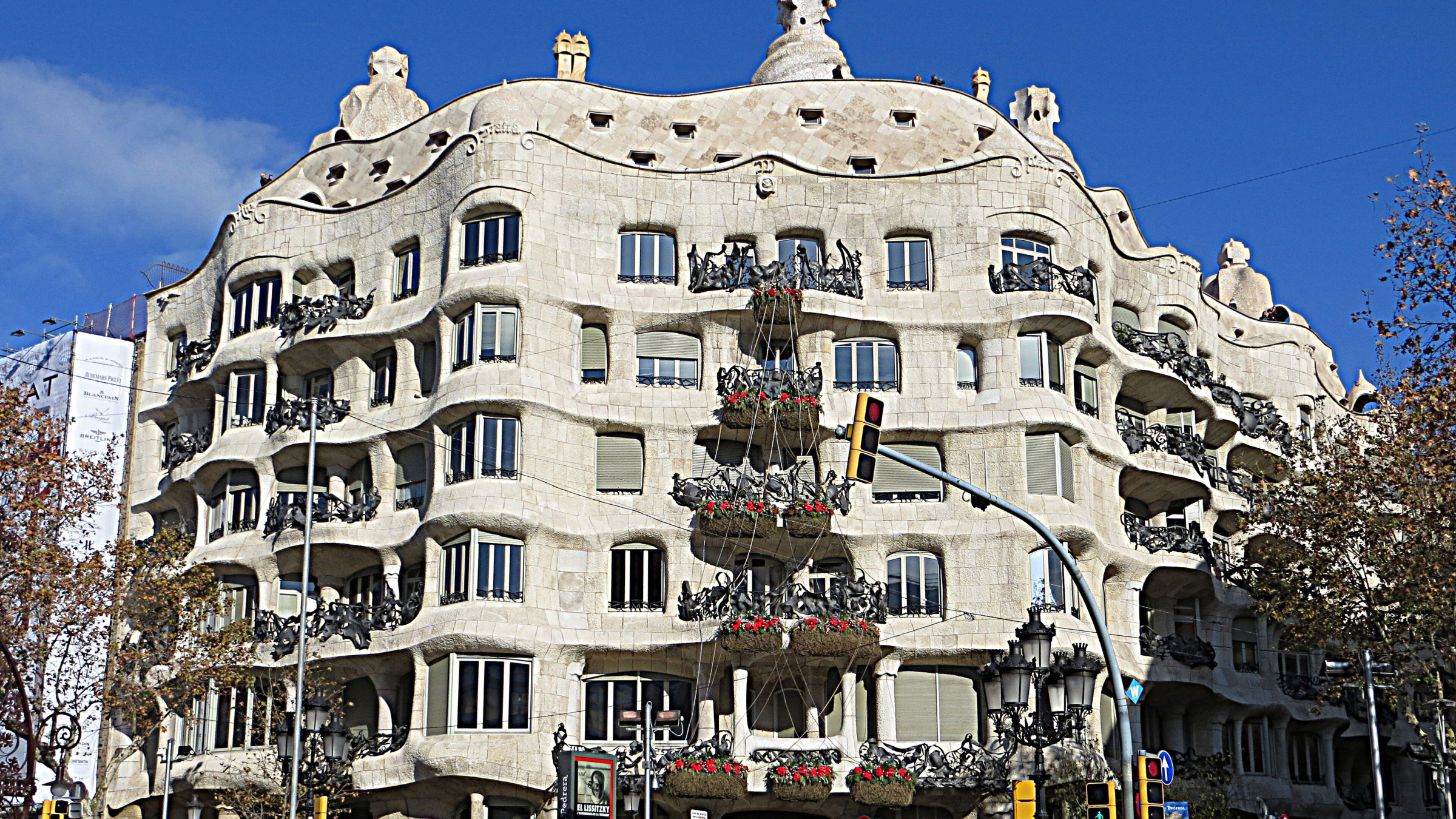 Casa Milà’s undulating stone façade and iron balconies beneath a clear blue Barcelona sky