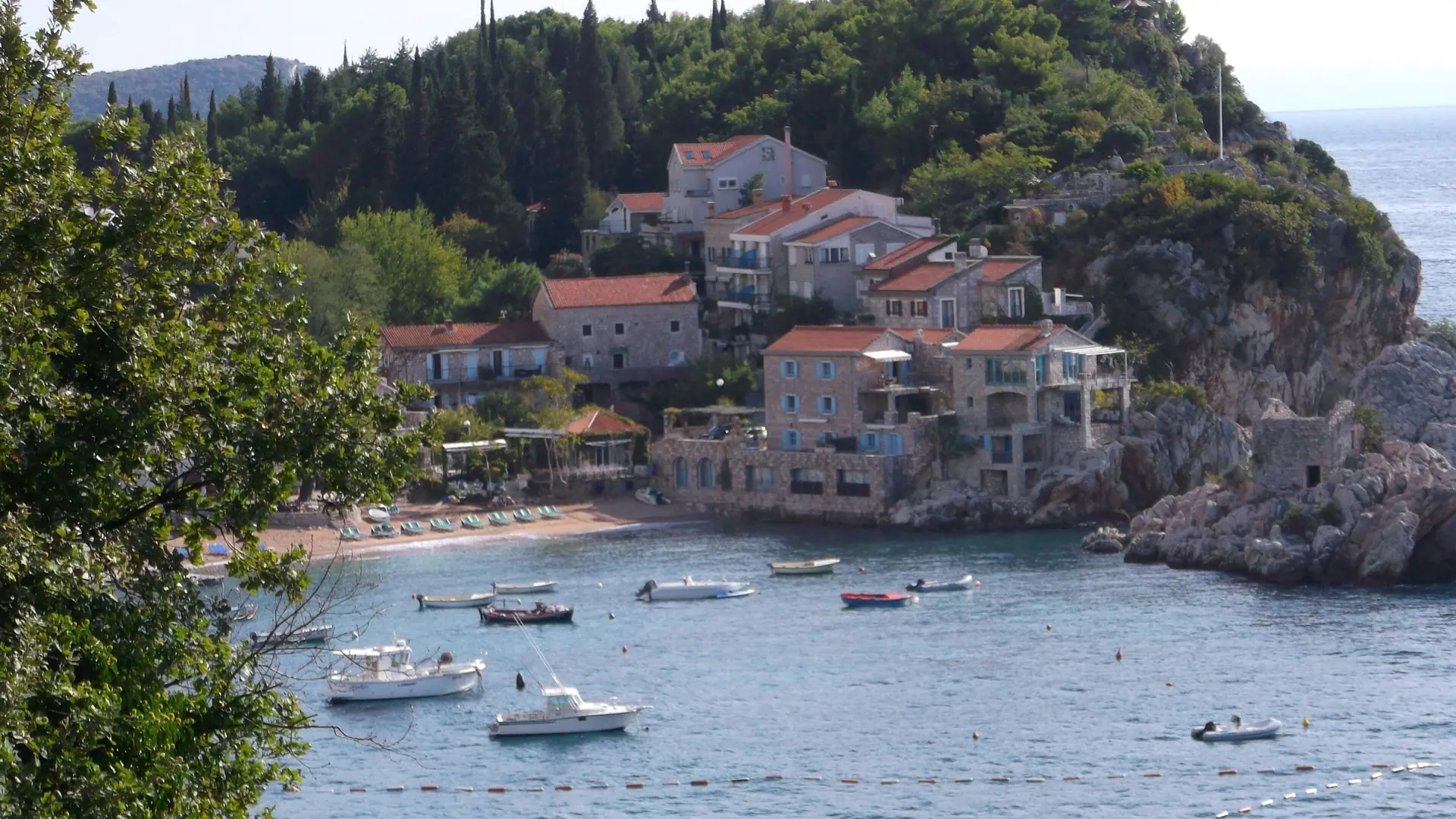 Pržno stone waterfront, hillside houses and small boats in daylight