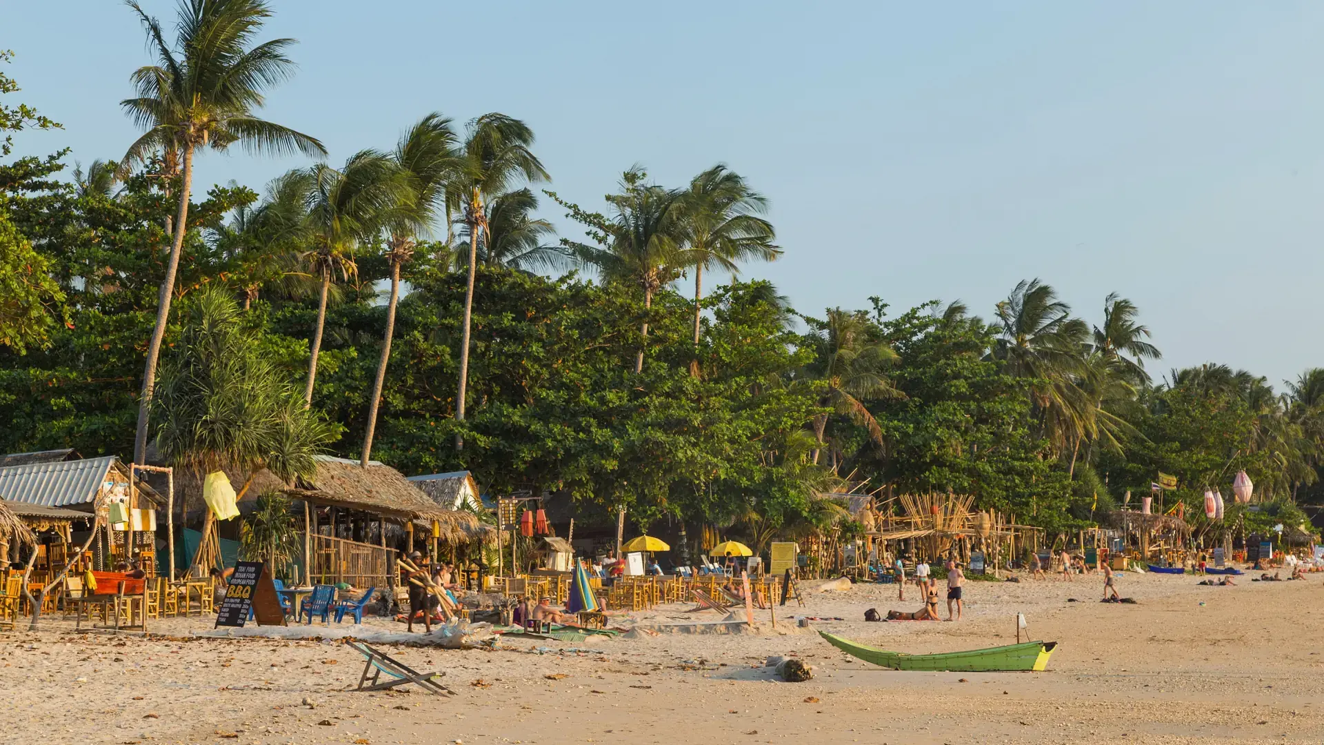 A green boat, palms and beach buildings at Klong Khong, illustrating wider Koh Lanta