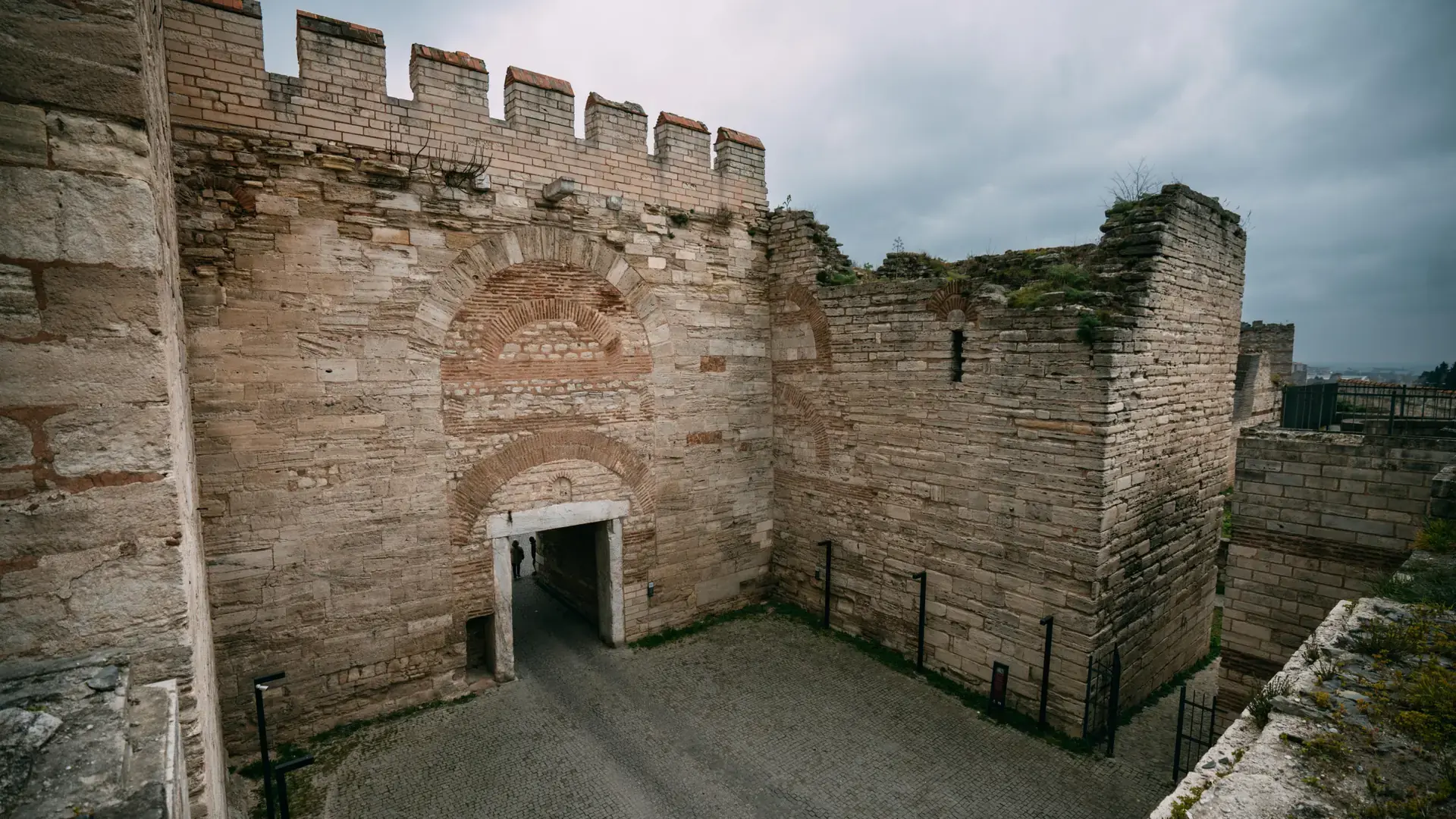 Weathered stone fortification passage in historic Trabzon beneath a cloudy sky